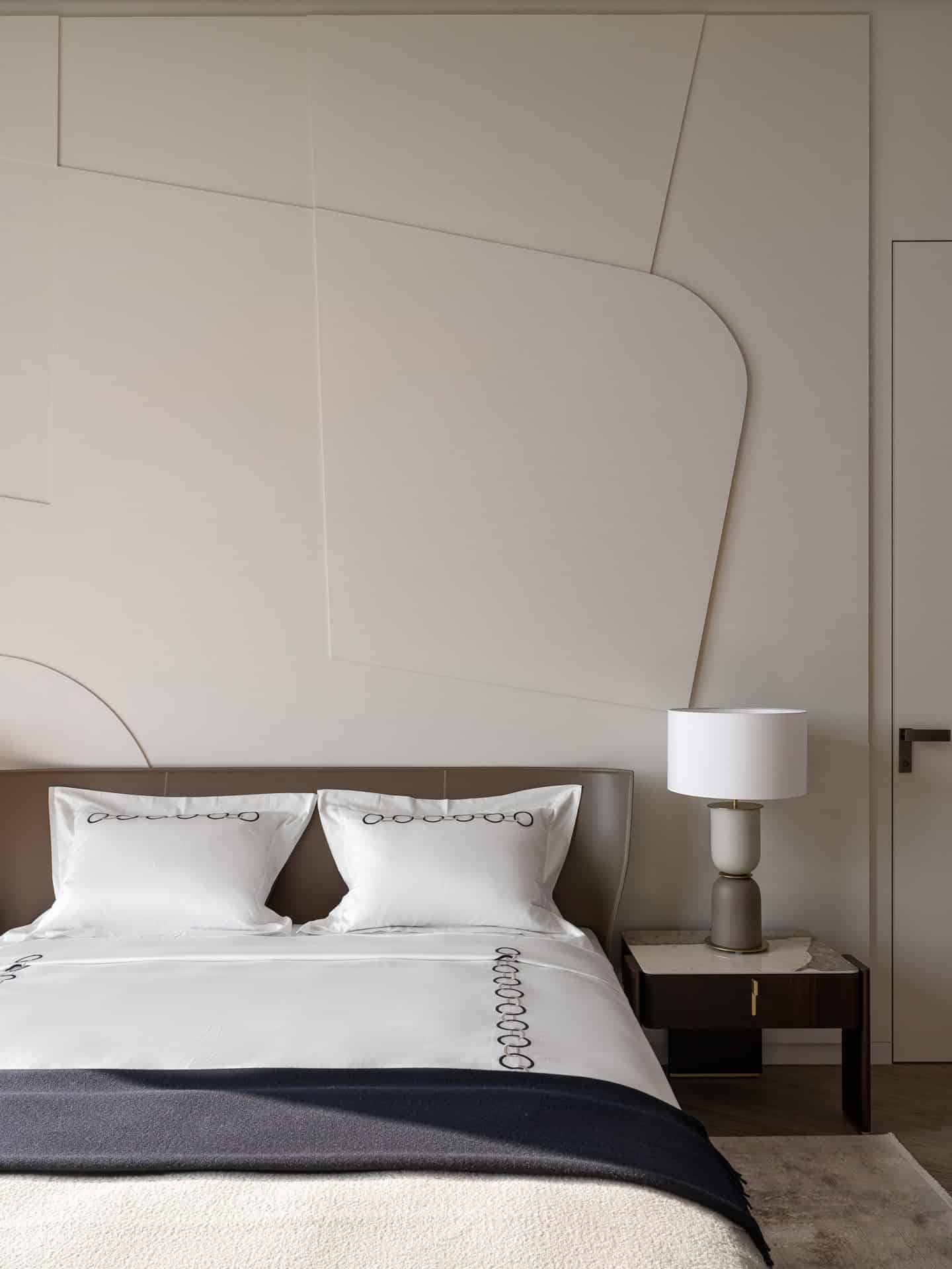 Angled Shot of Upholstered Bed Close-up view of upholstered bed with textured wall in the background.