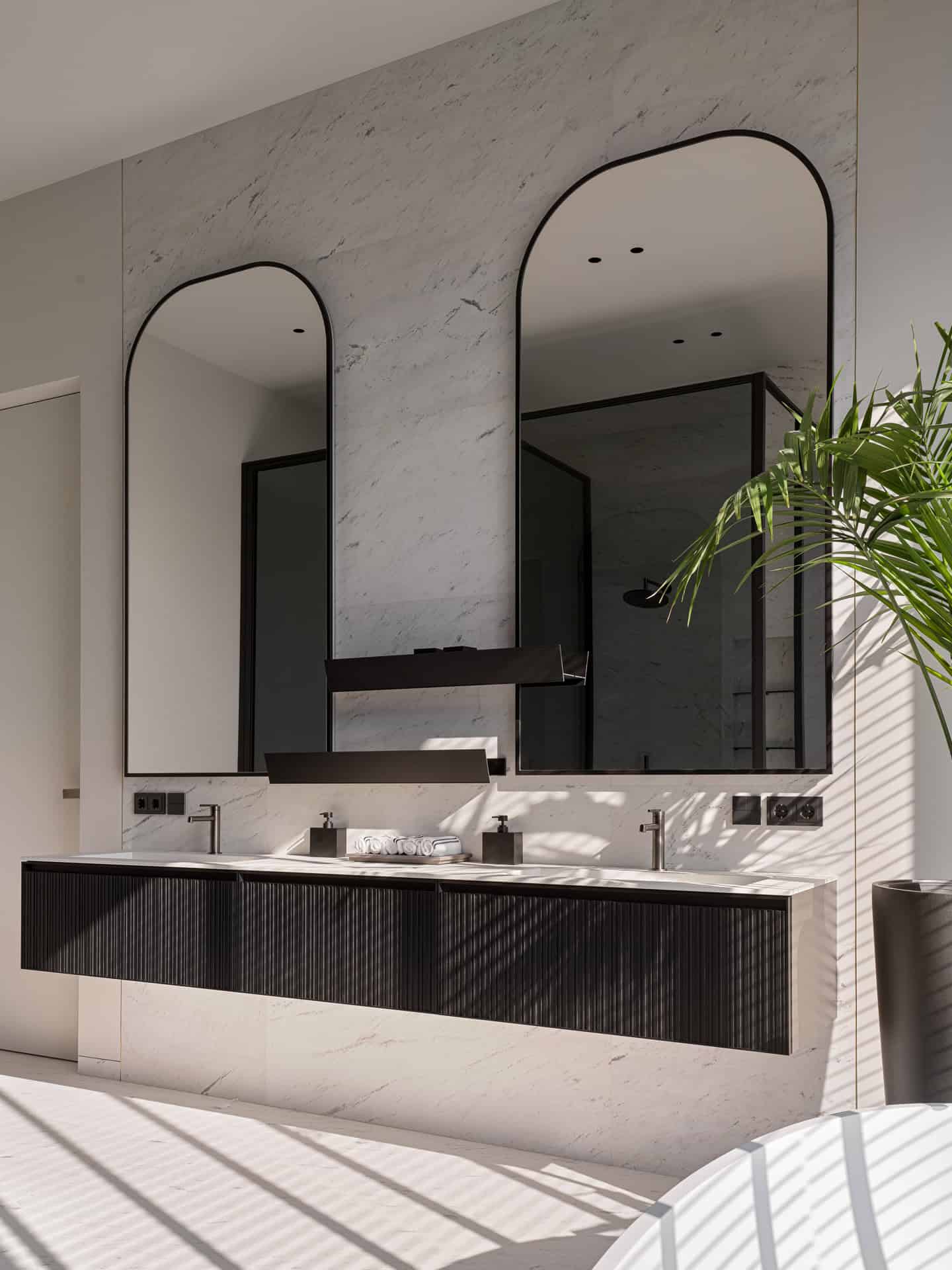 Arched Mirrors Over Black Vanity Black double vanity with arched mirrors in a minimalist marble bathroom.