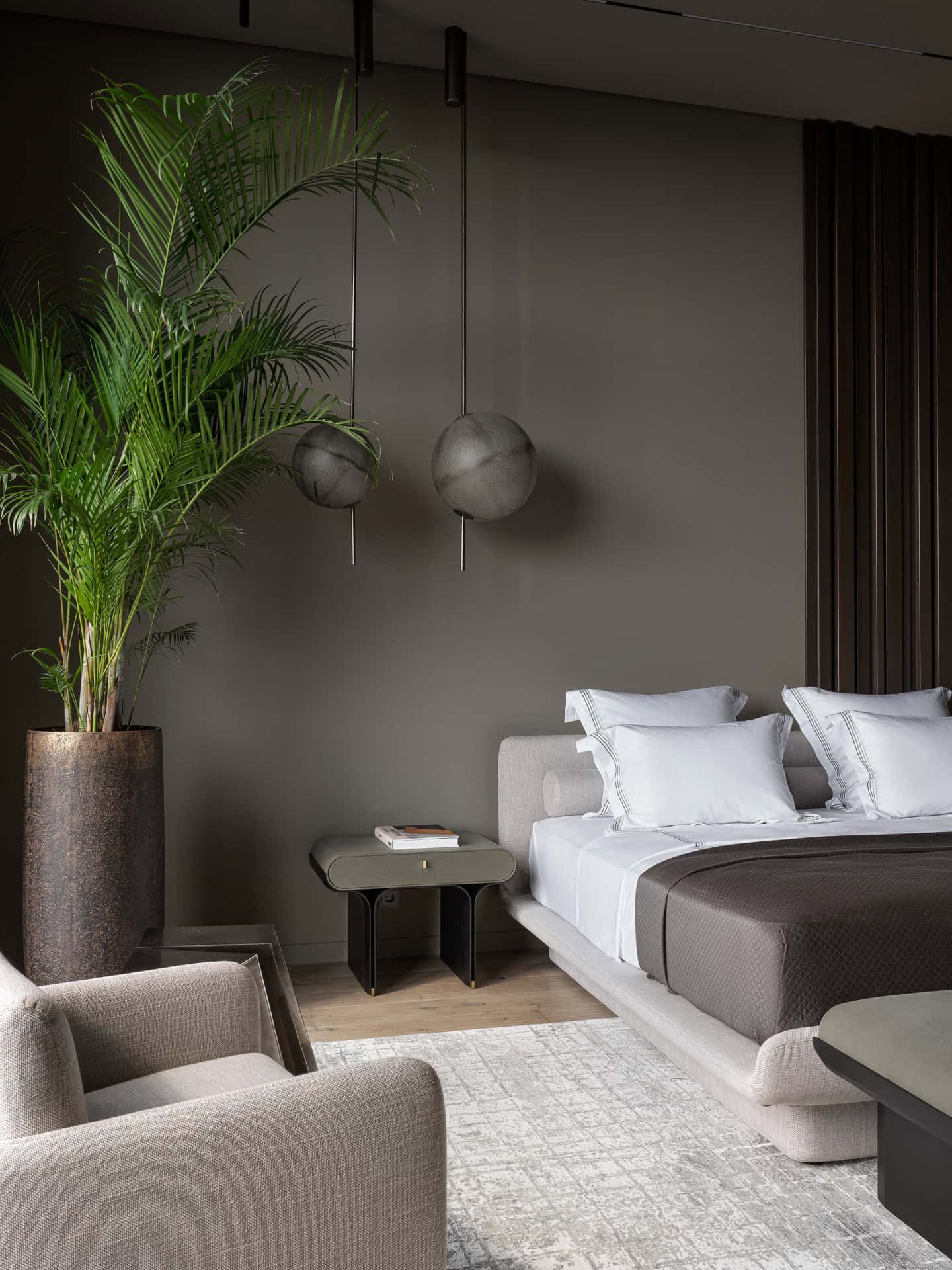 Bedside Globes and Tall Planter Modern bedroom with globe pendant lights and a tall planter beside the bed.