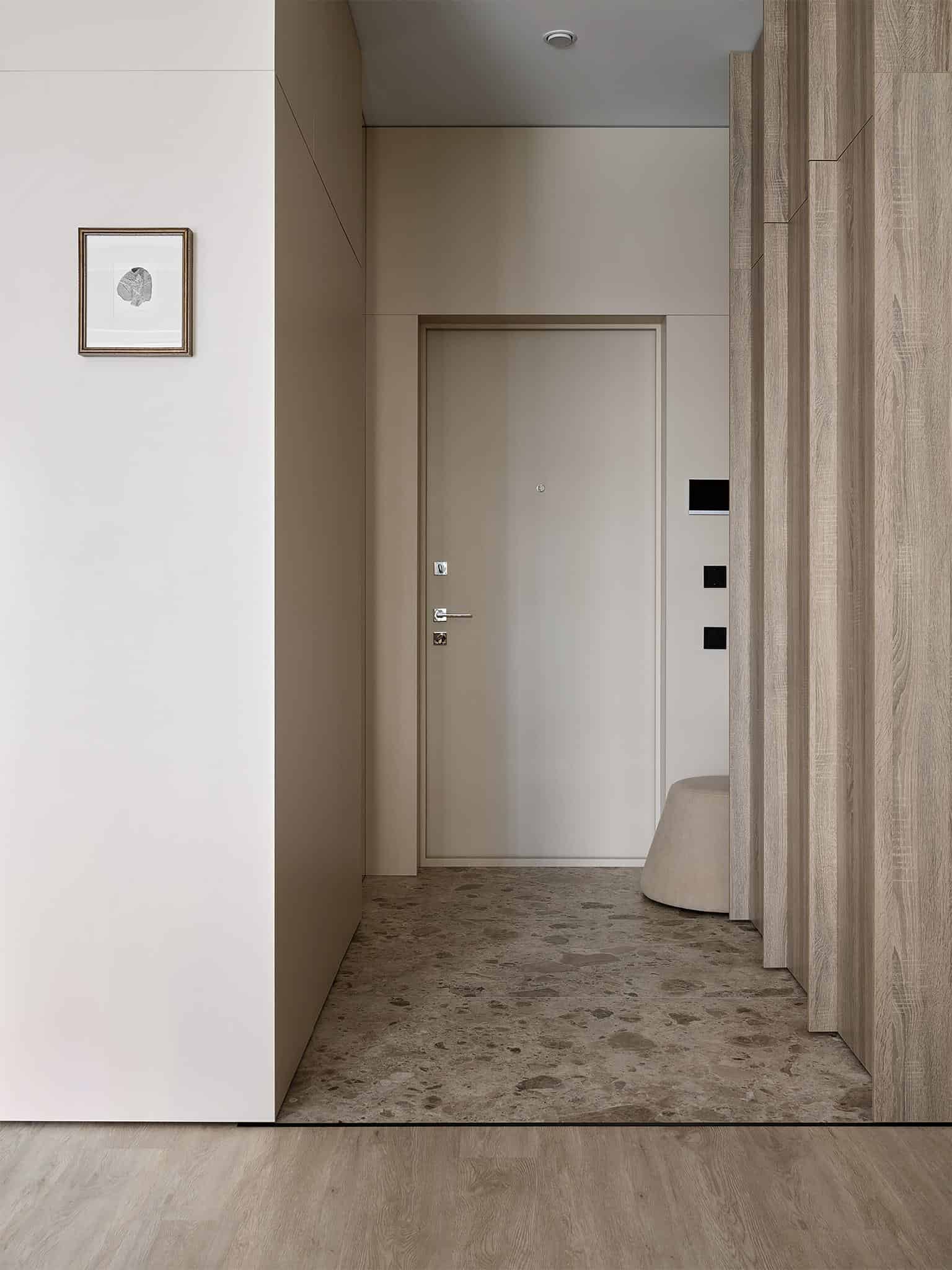 Beige Apartment Entryway with Stone Floor Modern entryway with beige walls and stone tile flooring in a cozy apartment.