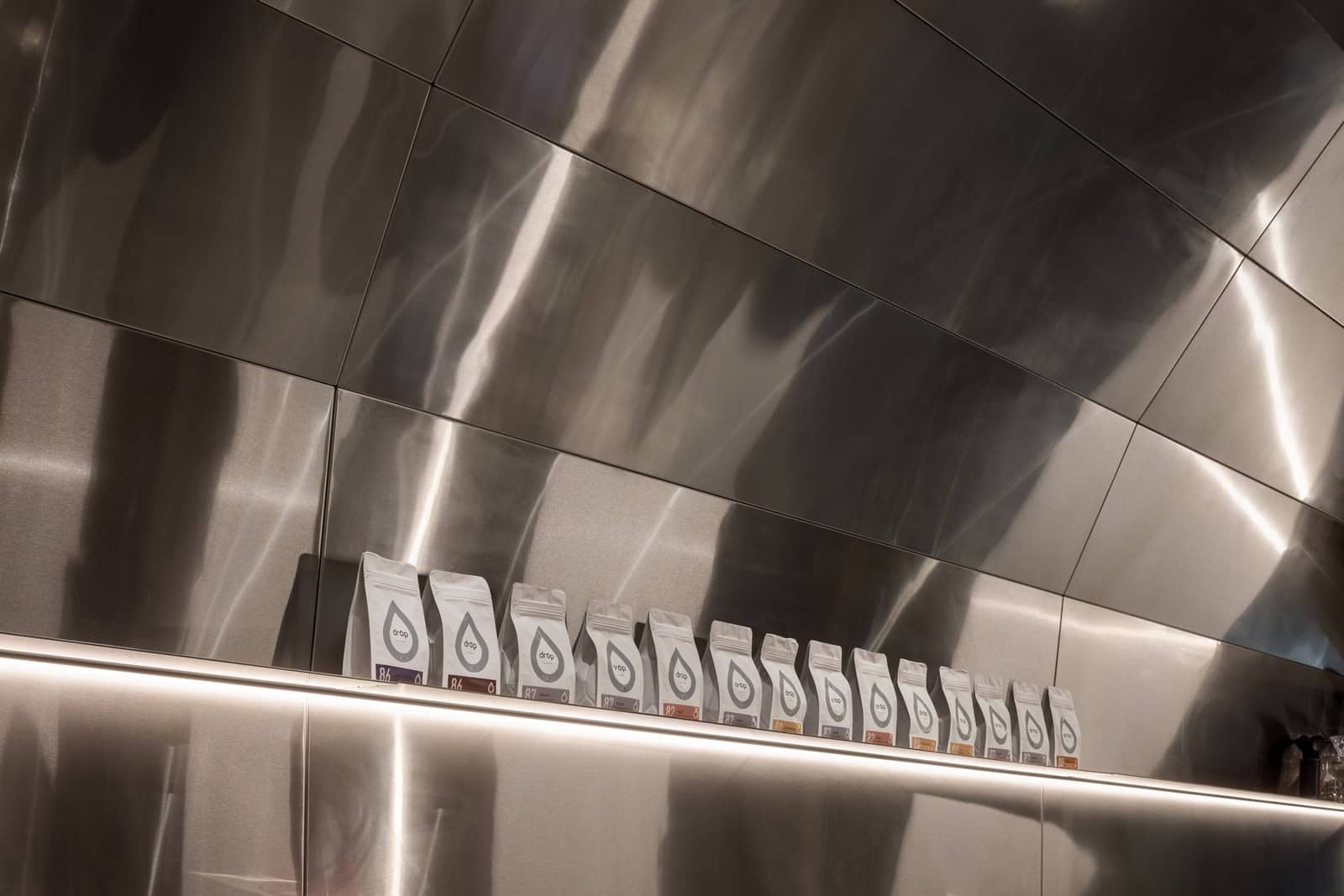 Coffee Shop Kovel Coffee Packaging Display Branded coffee packaging lined up on a shelf inside modern coffee shop