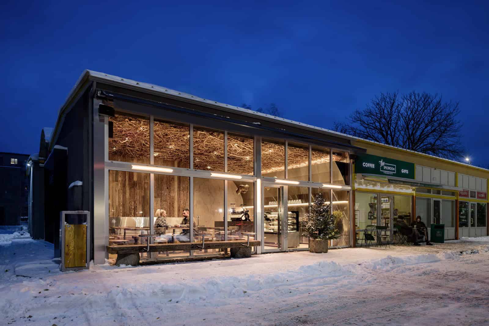 Coffee Shop Kovel Exterior Night Snow Snow-covered street and warm inviting interior of coffee shop with glass windows