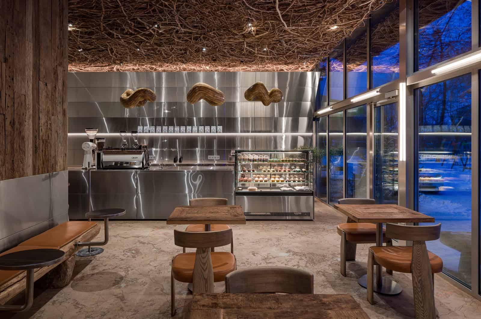 Coffee Shop Kovel Night View Modern Design Evening view of coffee shop with wood furniture, glass facade, and natural ceiling elements