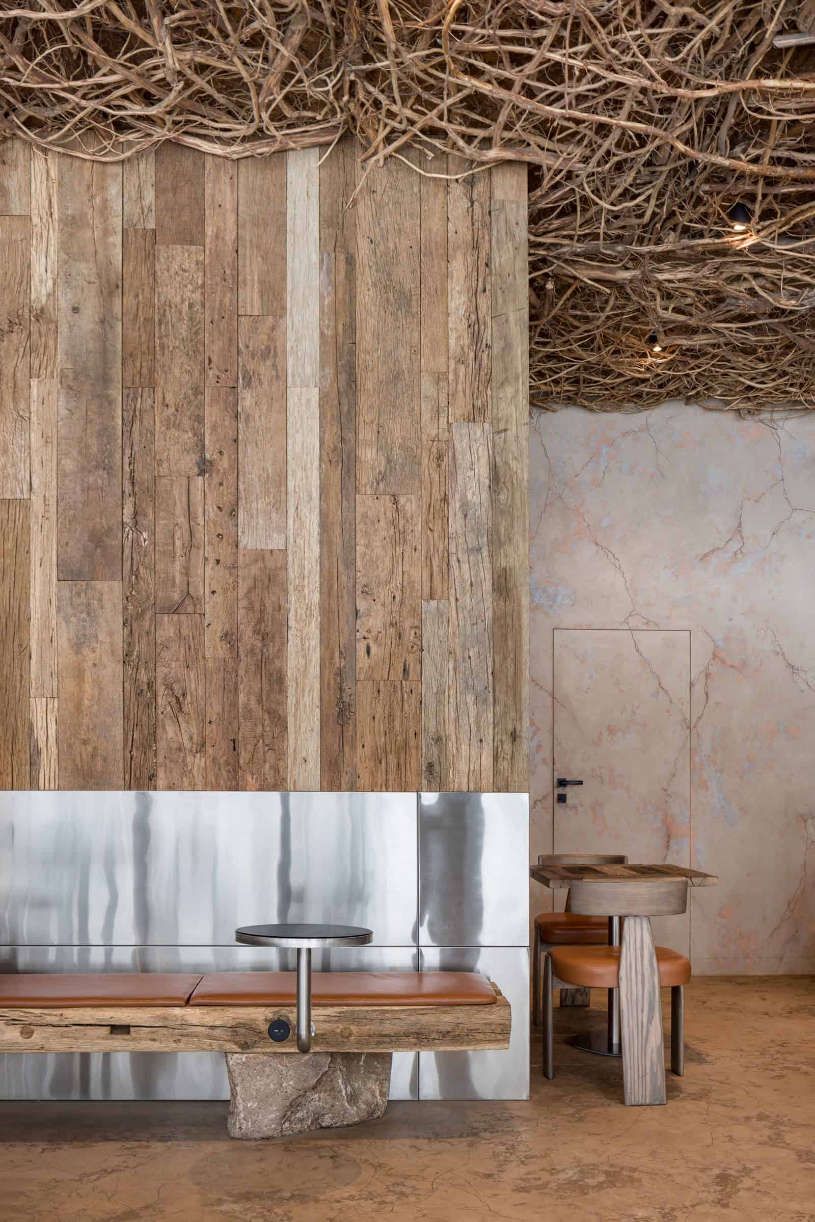Coffee Shop Kovel Reclaimed Wood Steel Wall Interior view showing contrast between reclaimed wood panels and polished steel wall