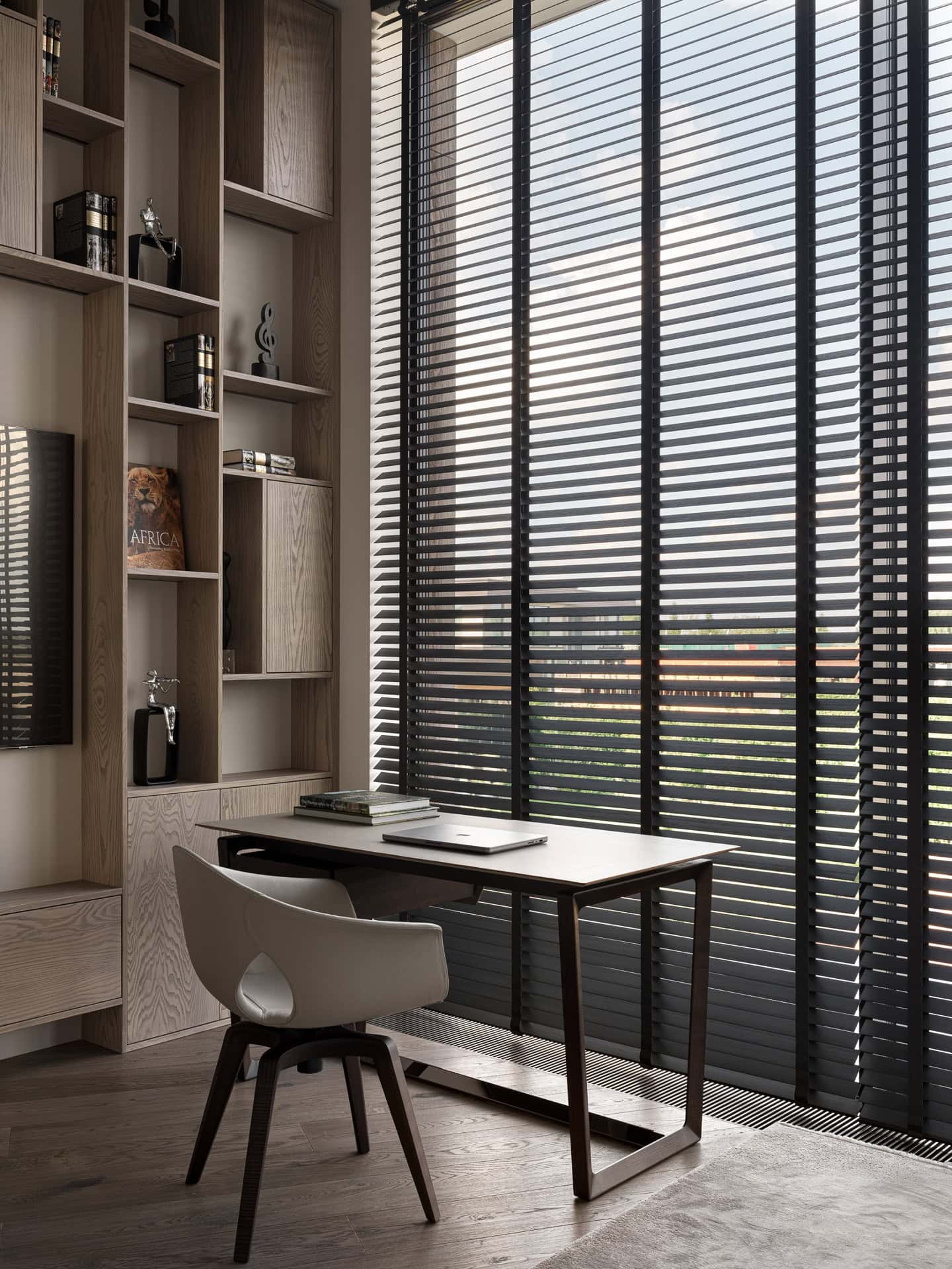 Compact Home Office with Blinds Minimal home office with a compact desk and tall windows covered by blinds.