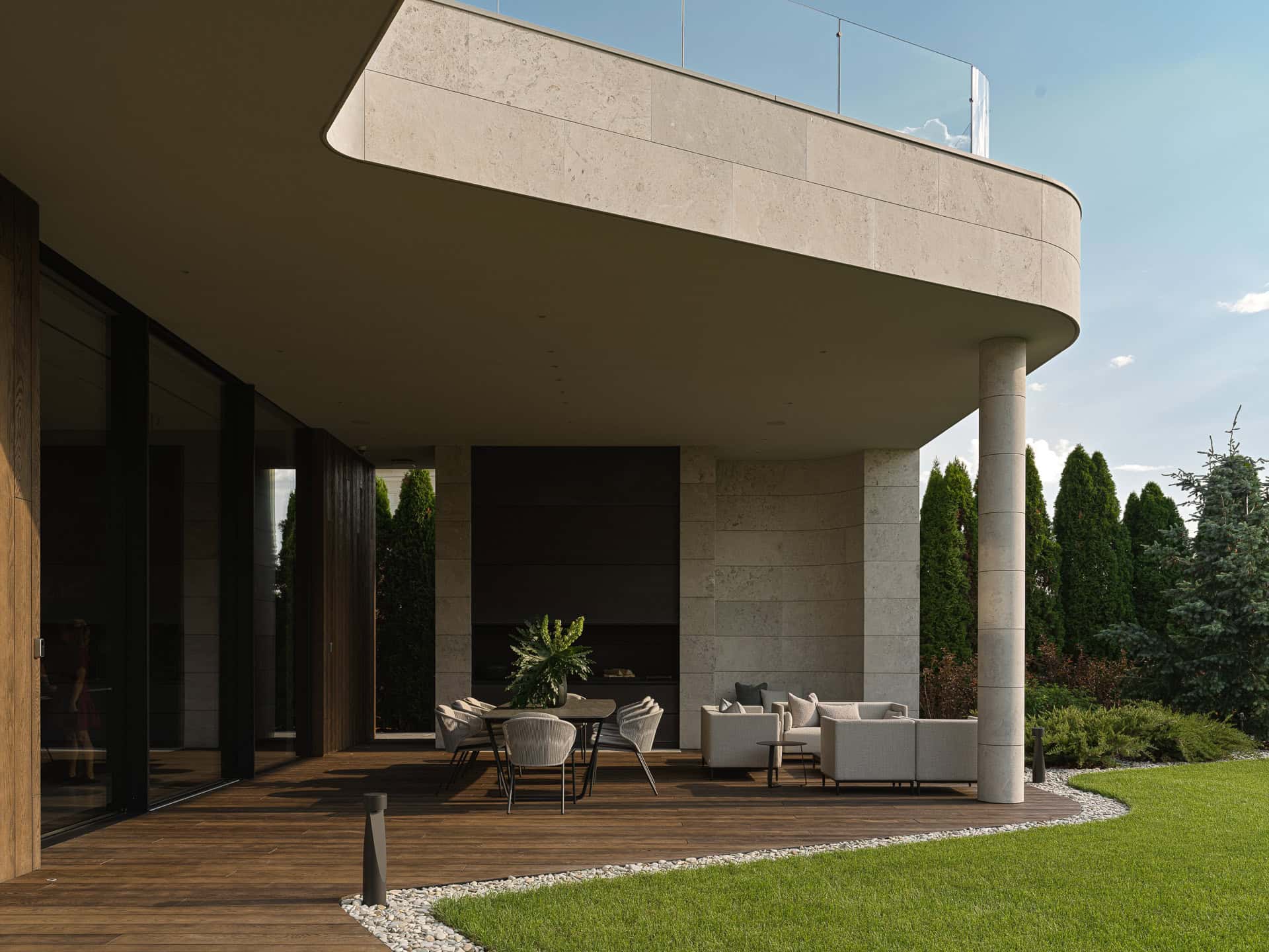 Covered Patio with Sofa and Dining Spacious covered terrace with outdoor lounge and dining set surrounded by greenery.