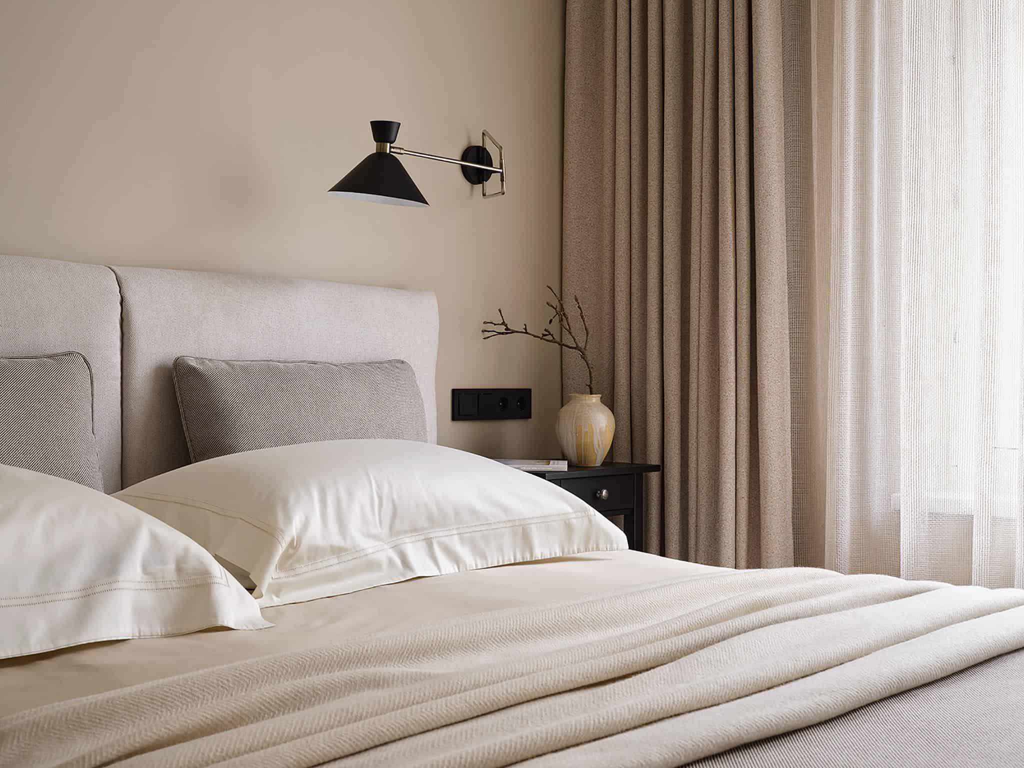 Cozy Bedroom Corner with Natural Light Cozy corner in the bedroom with beige curtains and soft sunlight filtering through sheer fabric.