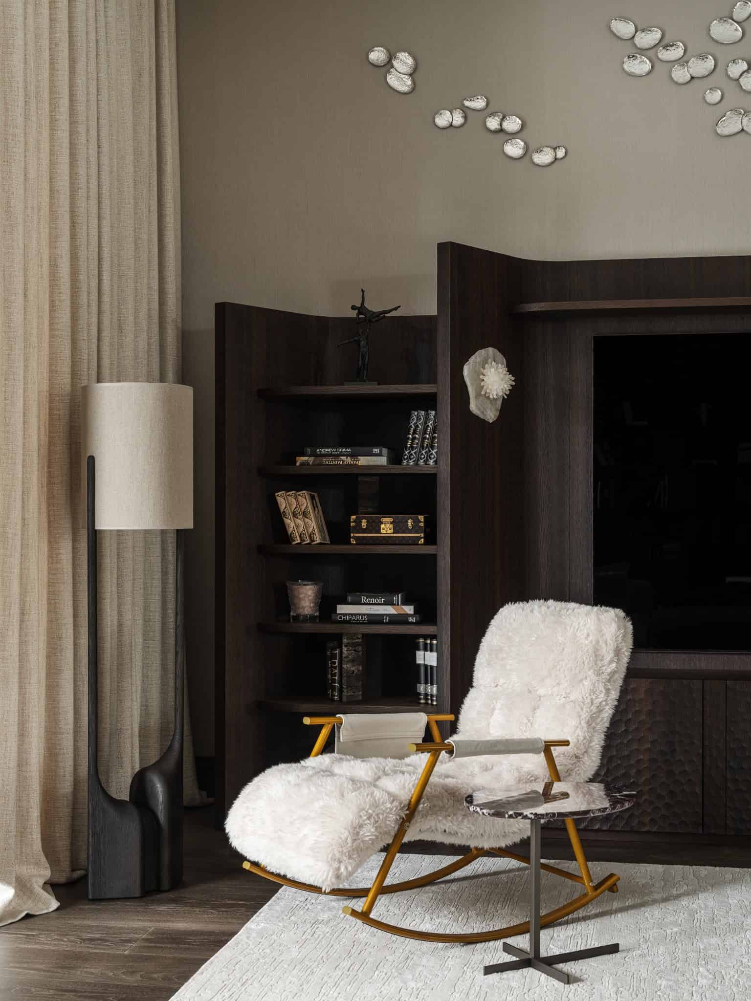 Cozy Reading Nook with Sheepskin Rocker Warm reading corner with a sheepskin-covered rocking chair and dark wood shelving.