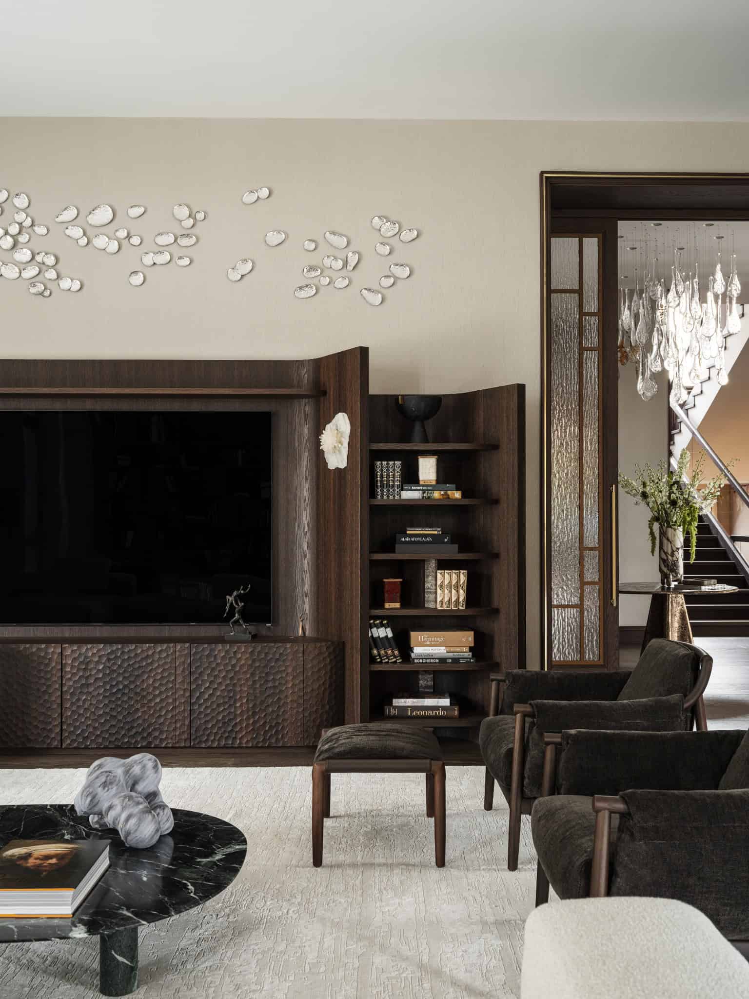 Dark Wood TV Wall and Green Velvet Chairs Living area featuring a dark wood entertainment unit and plush velvet chairs.