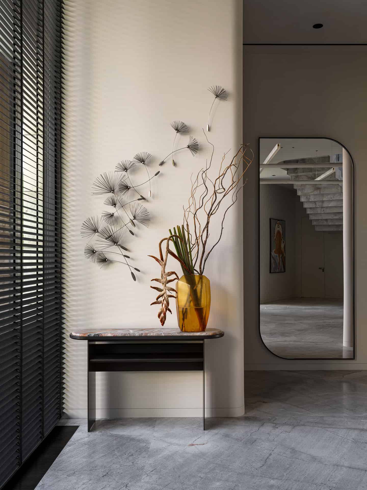 Decor Console with Yellow Glass Vase Yellow glass vase with sculptural dried florals on a console in a minimalist space.