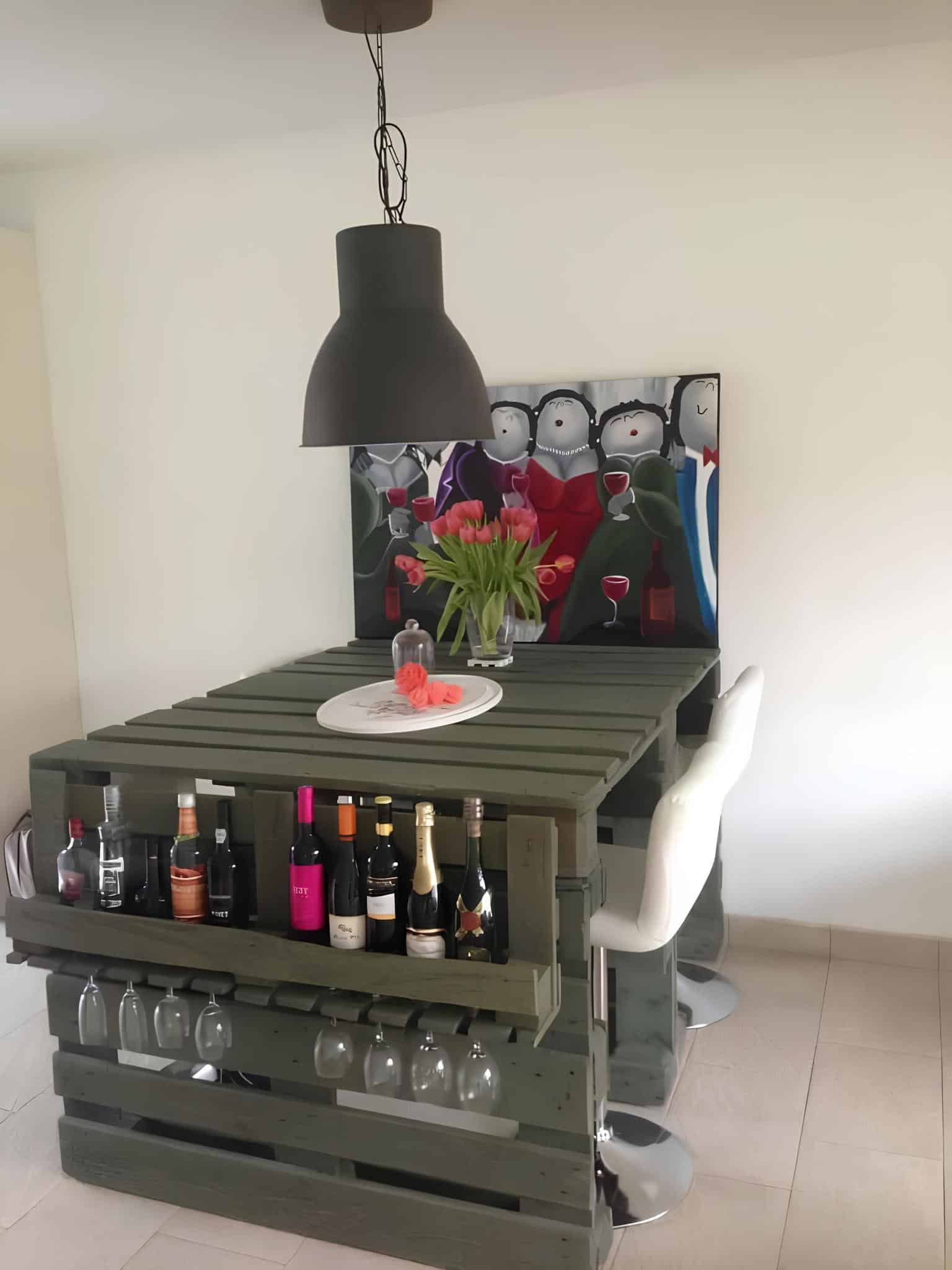 Homemade bar island made from pallets with built-in wine glass storage and bottles