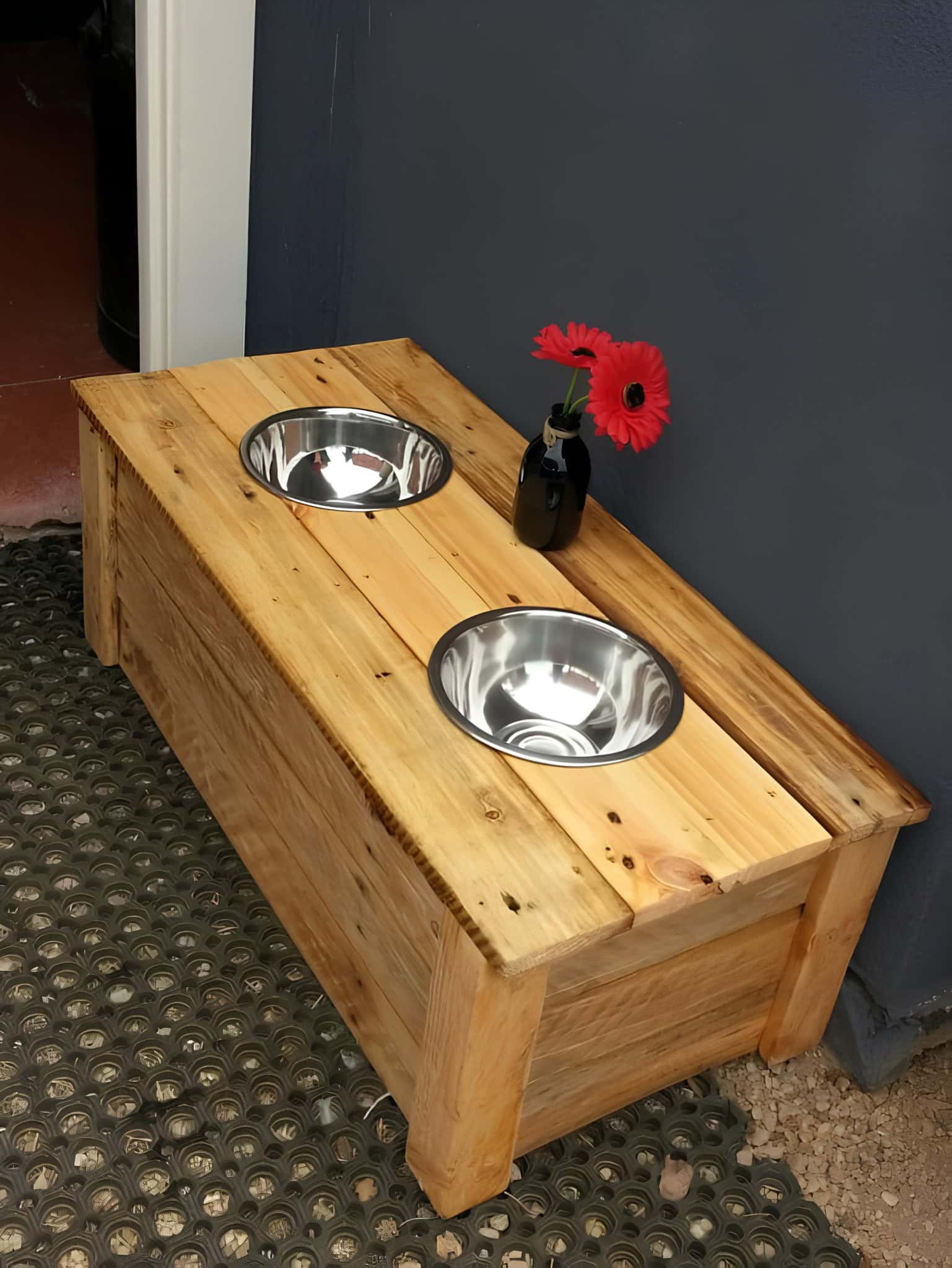Elevated pet feeder with dual bowls made from rustic pallet wood.