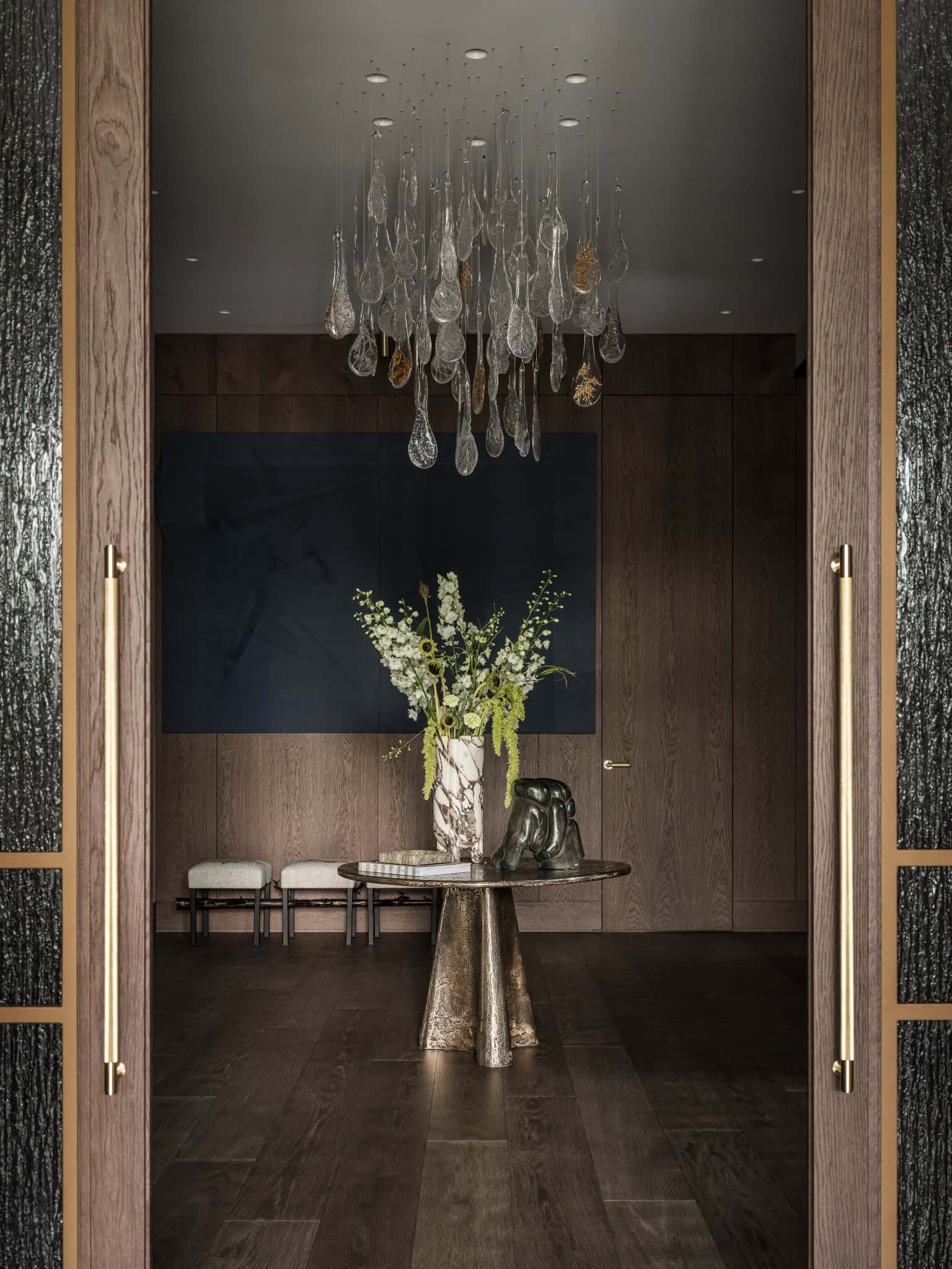 Elegant Foyer with Modern Chandelier Sophisticated foyer featuring a sculptural glass chandelier and dark wood finishes.