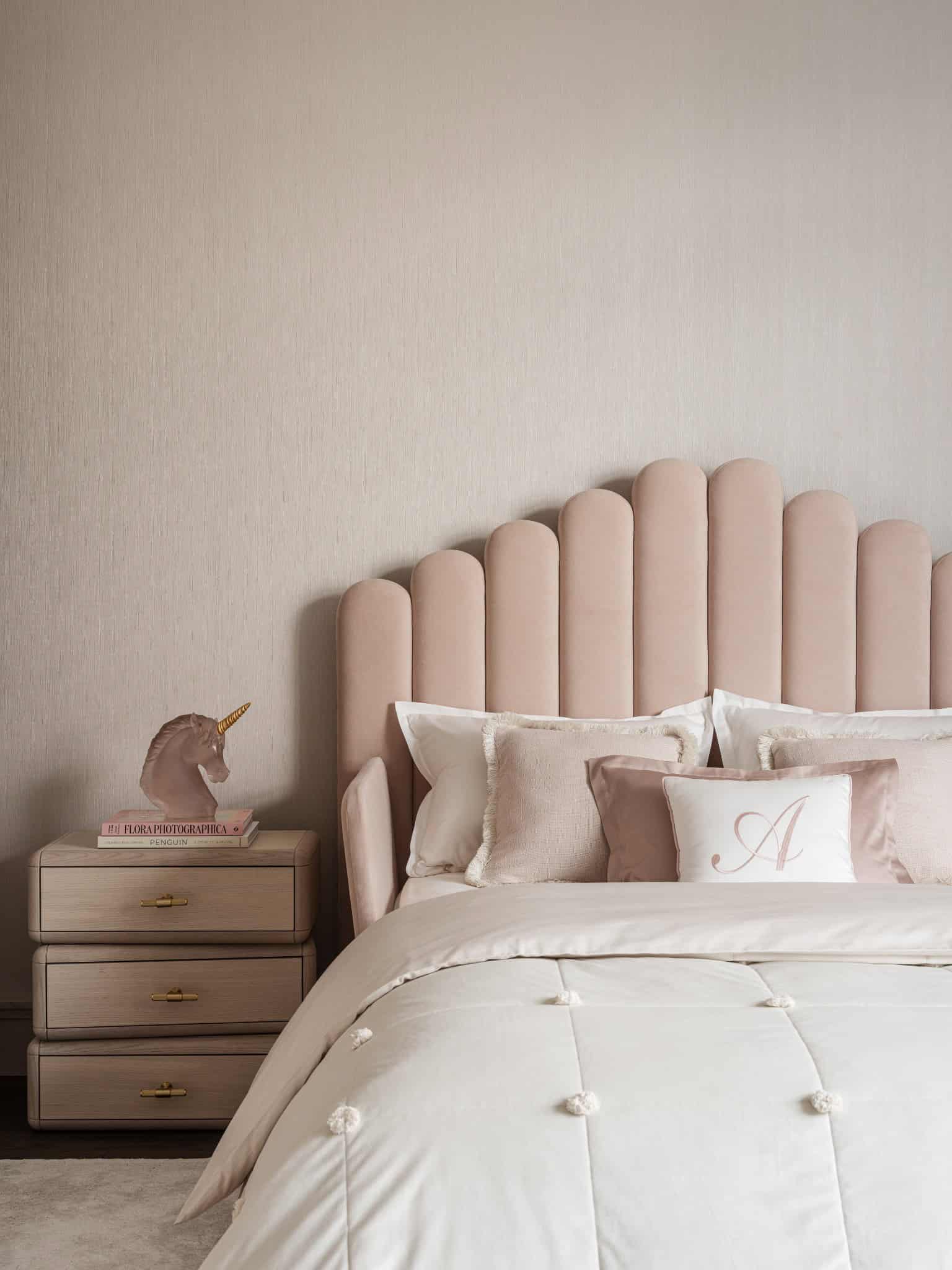 Elegant Pink Bedroom with Tufted Headboard Elegant children’s bedroom in pink tones with plush bed and whimsical lighting.