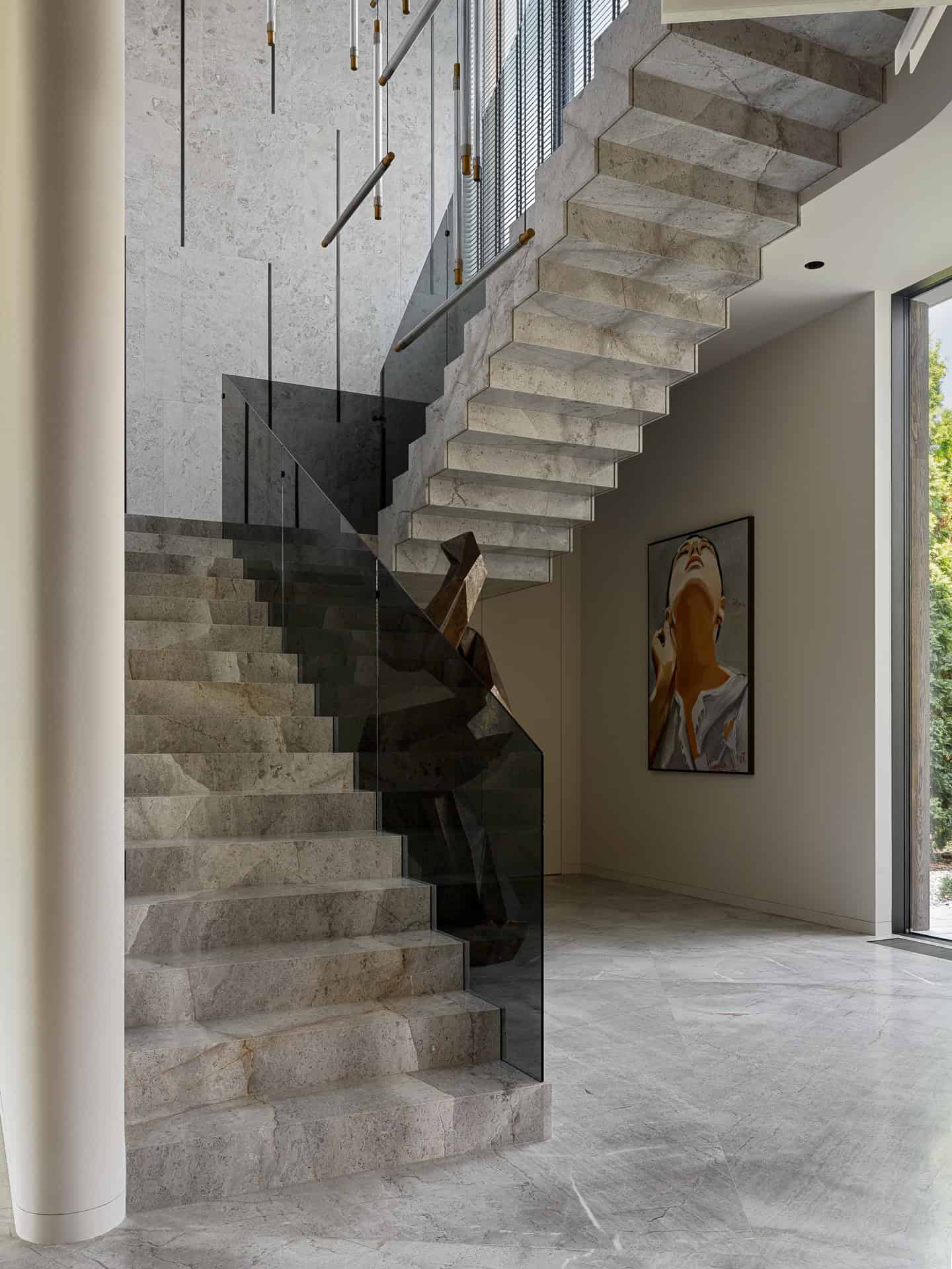Floating Stone Stairs with Glass Rail Floating stone staircase with glass railing in modern entryway.