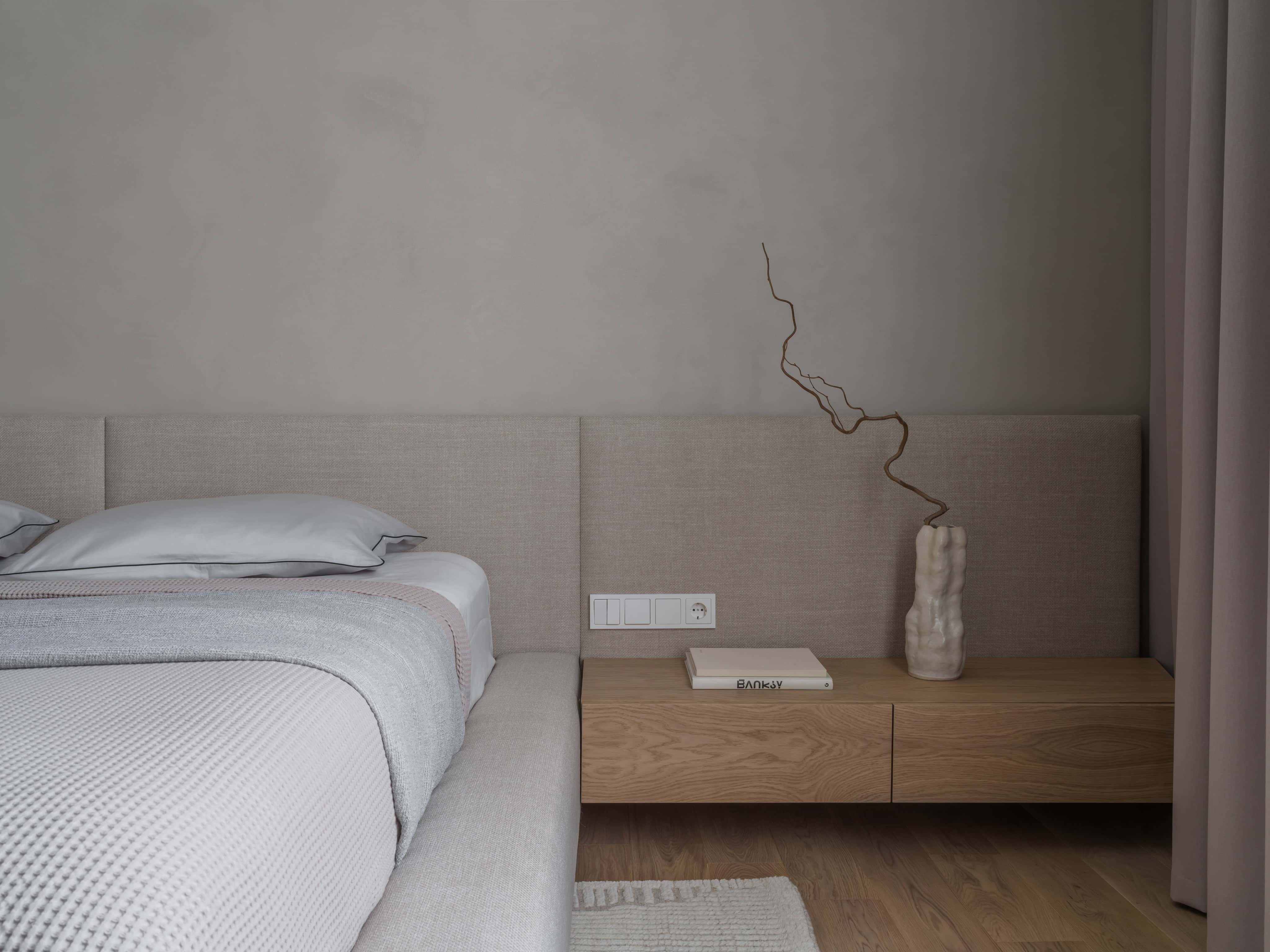 Floating Wooden Desk with Glass Closet Floating oak desk in a bedroom space with view of a walk-in glass wardrobe.
