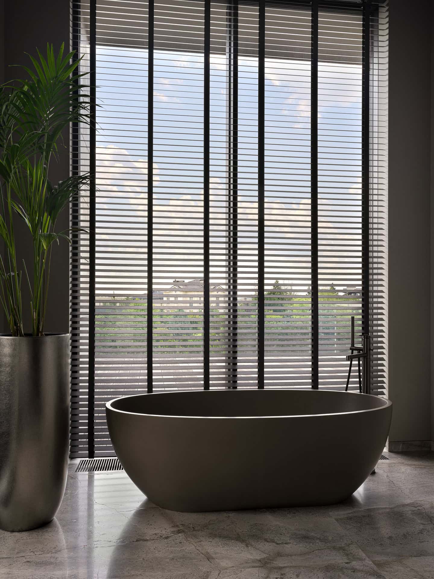 Freestanding Bathtub Under Window Elegant freestanding bathtub positioned beneath a large window with blinds.
