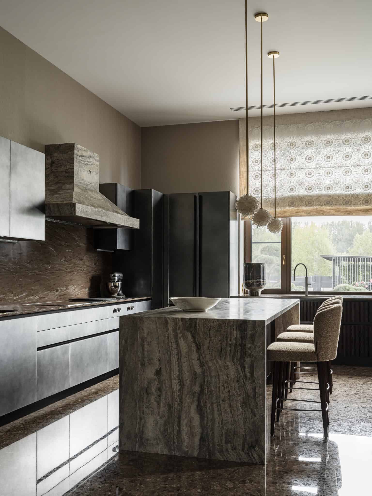 Full View of Marble Clad Modern Kitchen Contemporary kitchen with marble surfaces and dark cabinetry.