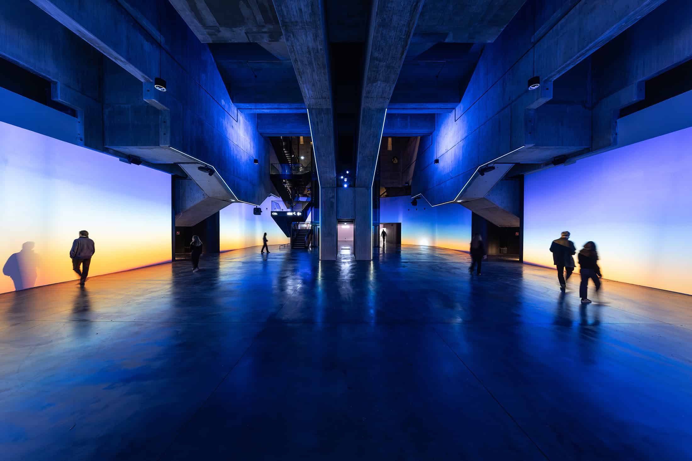 Geode Color Gradient Interior Lights Colorful interior installation with concrete beams and gradient walls at La Géode.