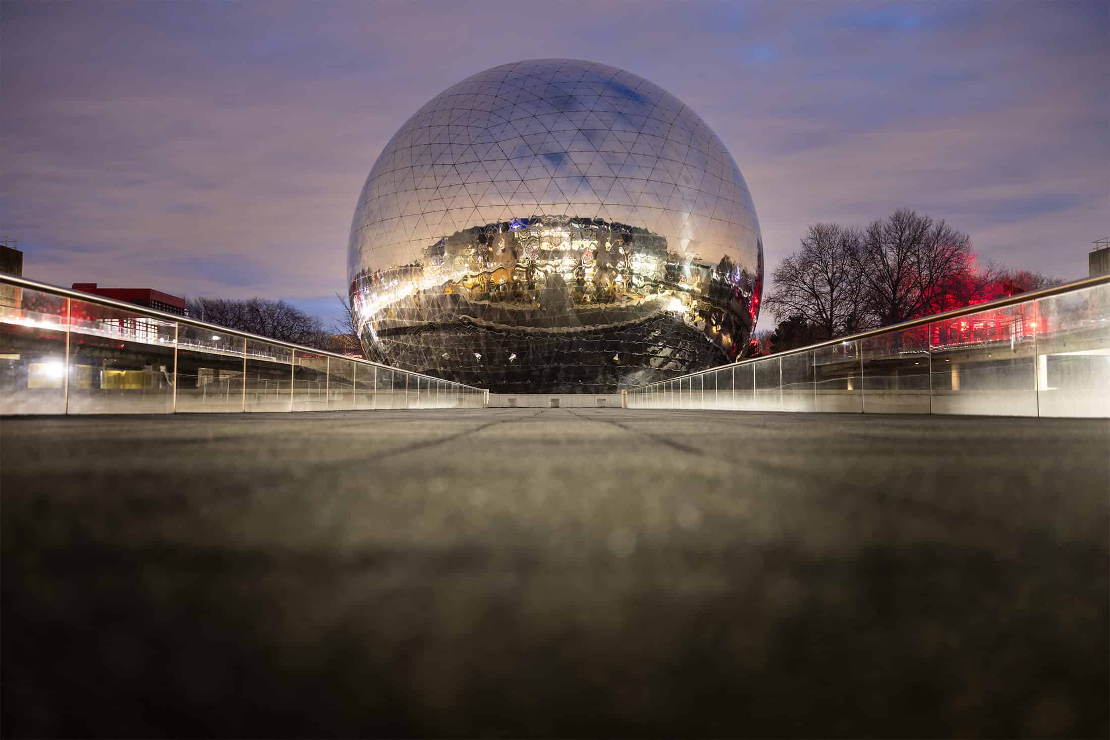 Geode Spherical Exterior Paris Night Night view of La Géode's reflective sphere in Paris, surrounded by soft sky lighting.