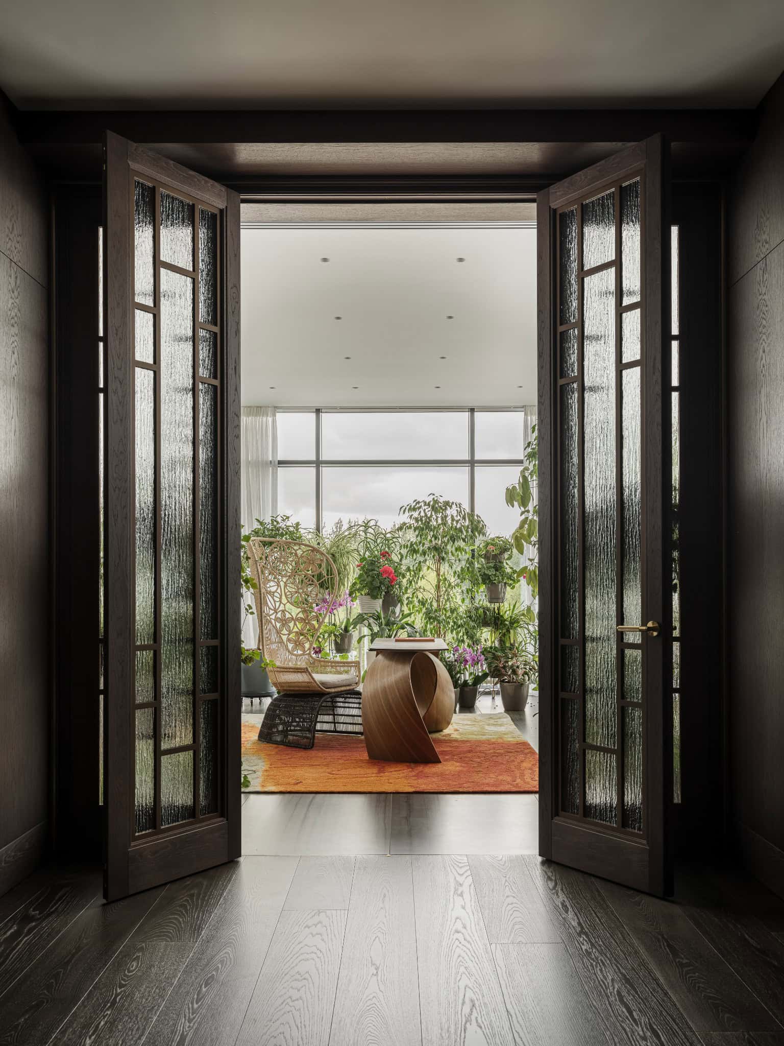Glass Doors Opening to Indoor Garden Double glass doors reveal lush indoor garden room with natural light.