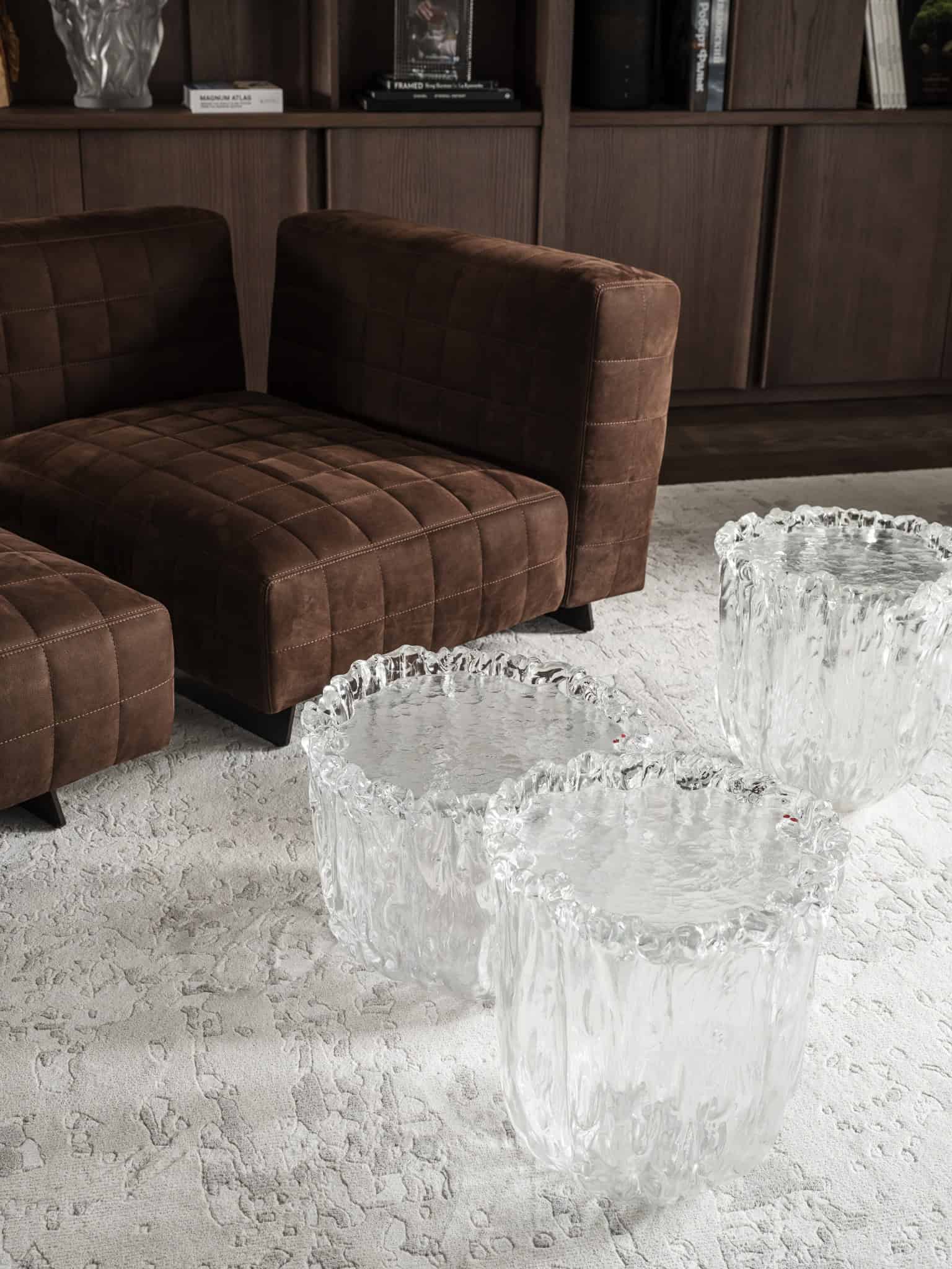 Glass Side Tables on Textured Rug Clear glass side tables with organic form on a light textured rug.