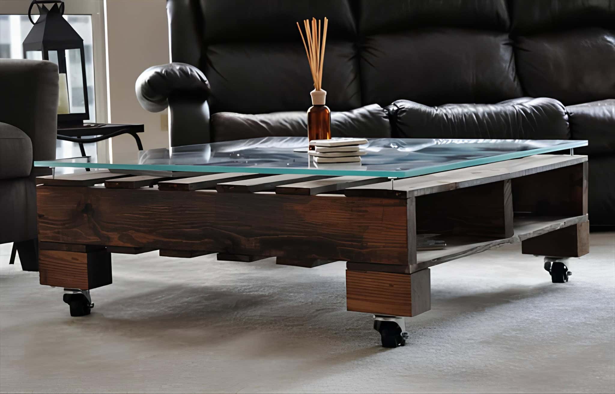 Elegant dark pallet coffee table with a sleek glass top and modern wheels.