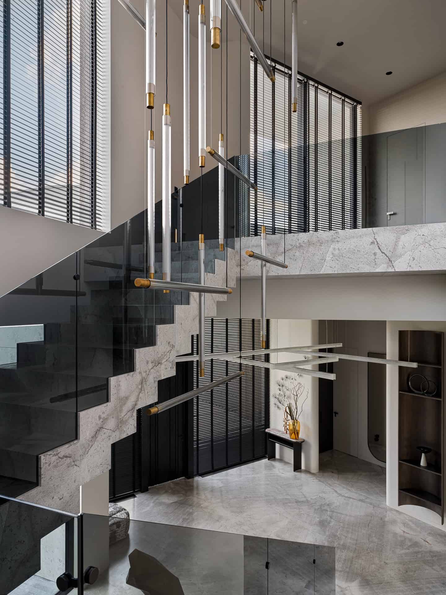 Hanging Lights Over Staircase Modern chandelier installation suspended over open staircase.