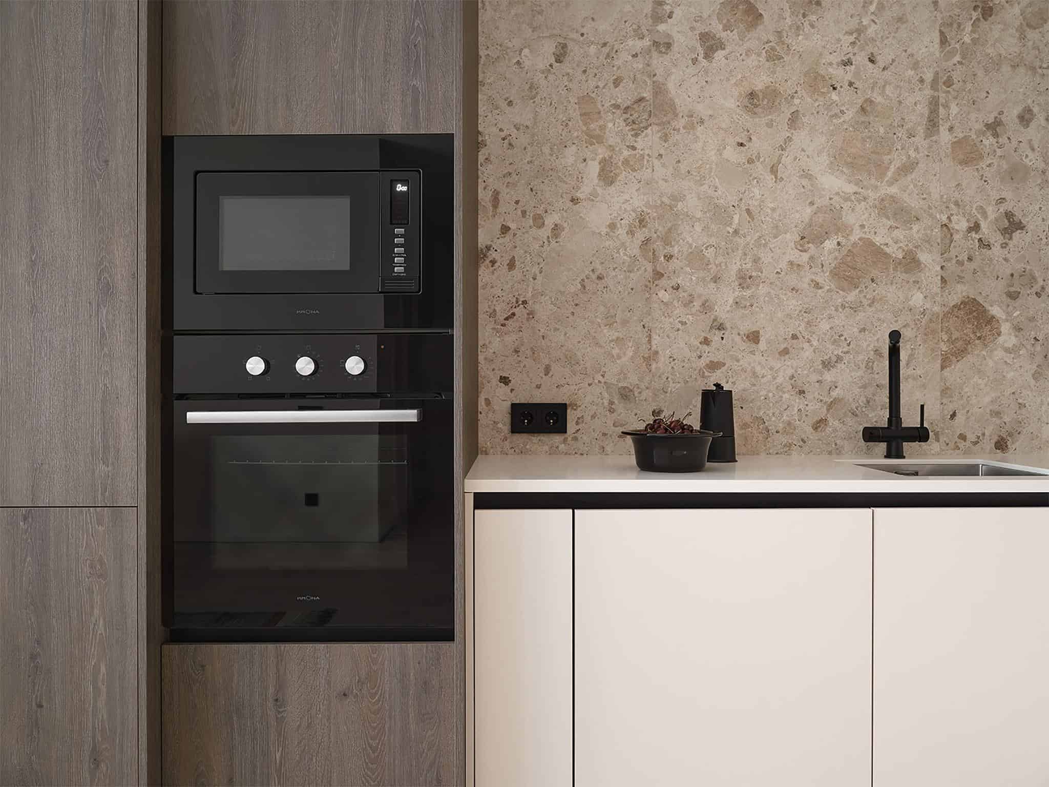 Kitchen Close-Up with Black Fixtures and Stone Wall Close-up of kitchen area with black fixtures and natural stone backsplash.