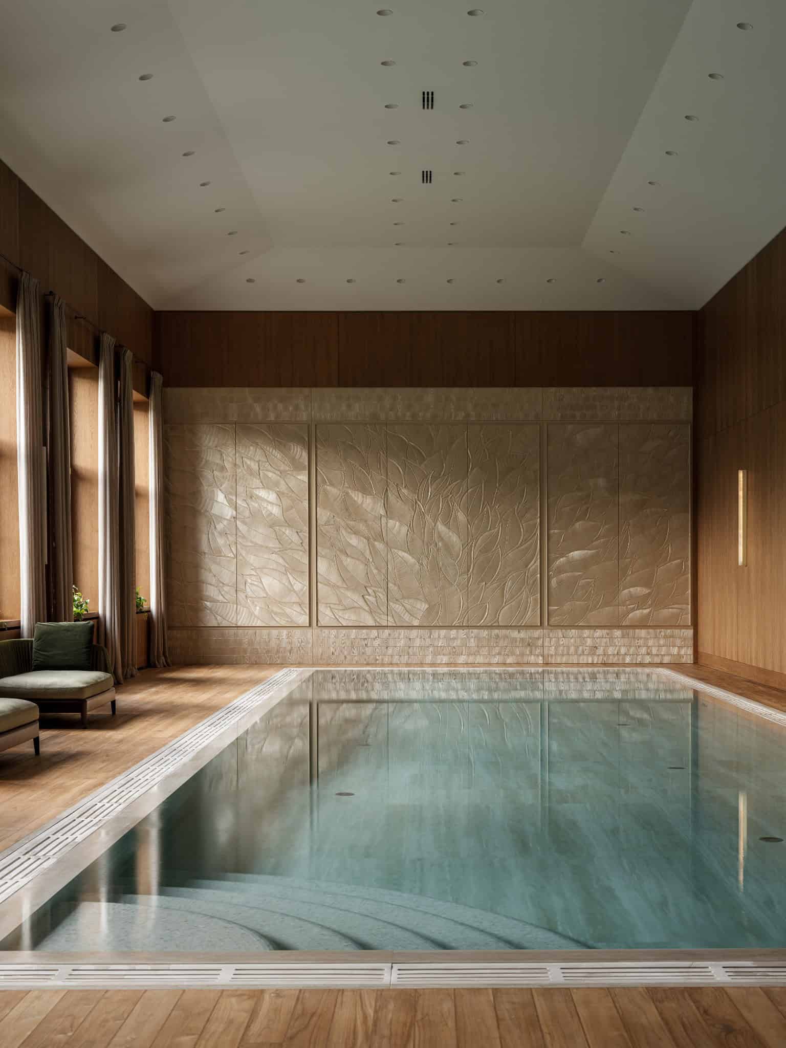 Luxury Pool Room with Wood and Stone Refined indoor pool with wooden walls and sculptural stone panel.