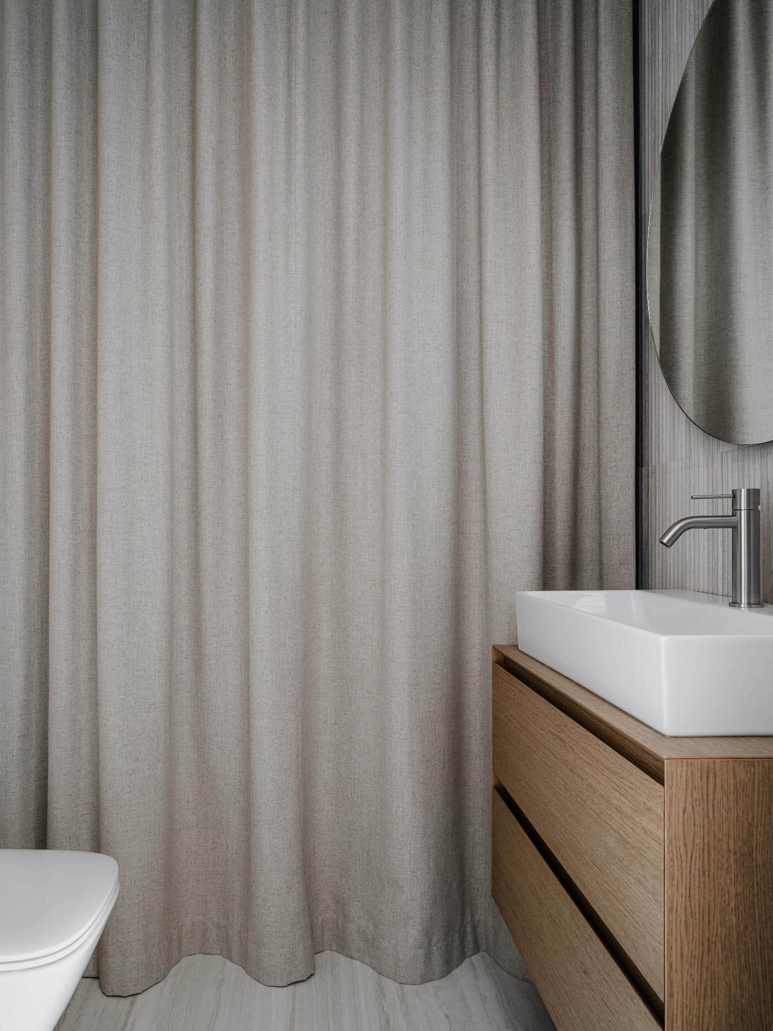 Minimal Bathroom With Curtains And Wooden Vanity Minimal bathroom with curtains and wooden vanity.