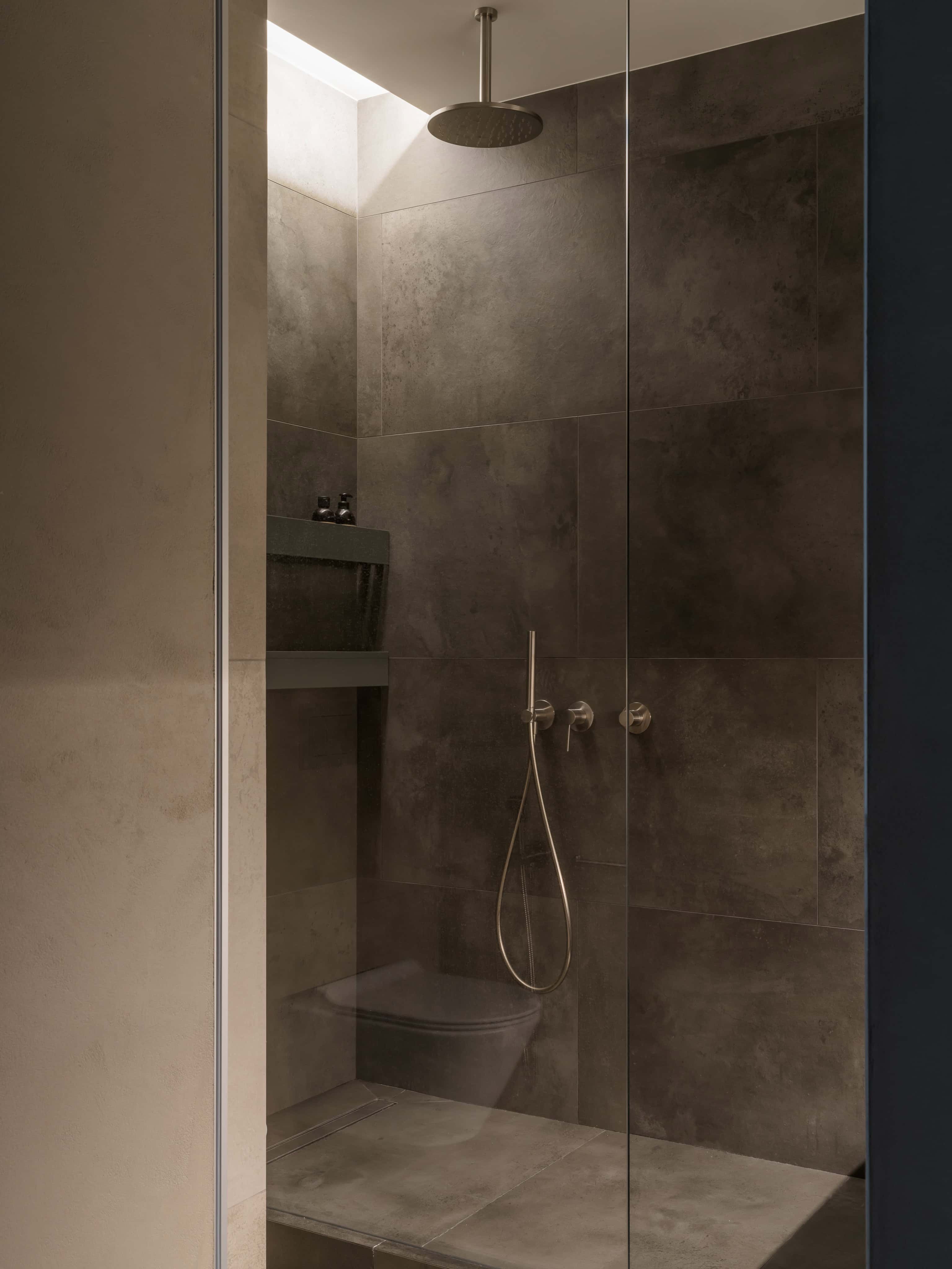 Minimalist Glass Shower Corner Minimalist bathroom corner with a walk-in glass shower and rainhead.