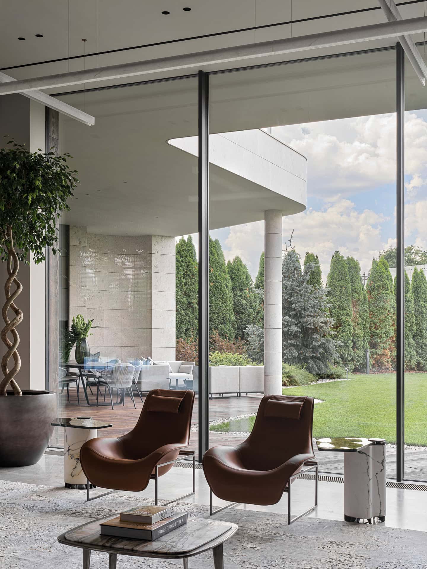 Modern Lounge Chairs Garden View Elegant leather lounge chairs facing floor-to-ceiling windows overlooking garden.