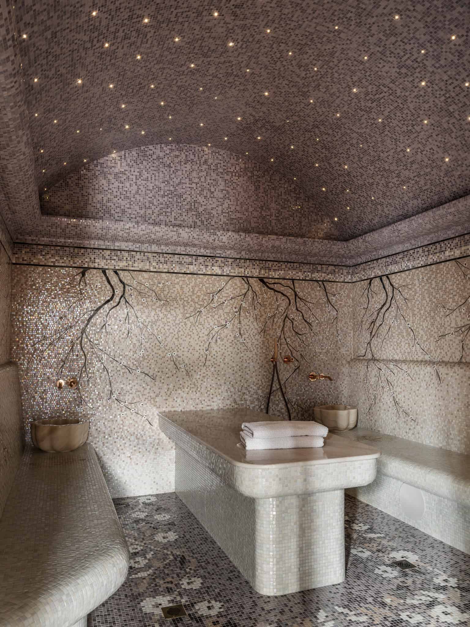 Mosaic Tiled Hammam with Branch Mural Luxurious hammam featuring mosaic tile ceiling and blossom branch mural on walls.