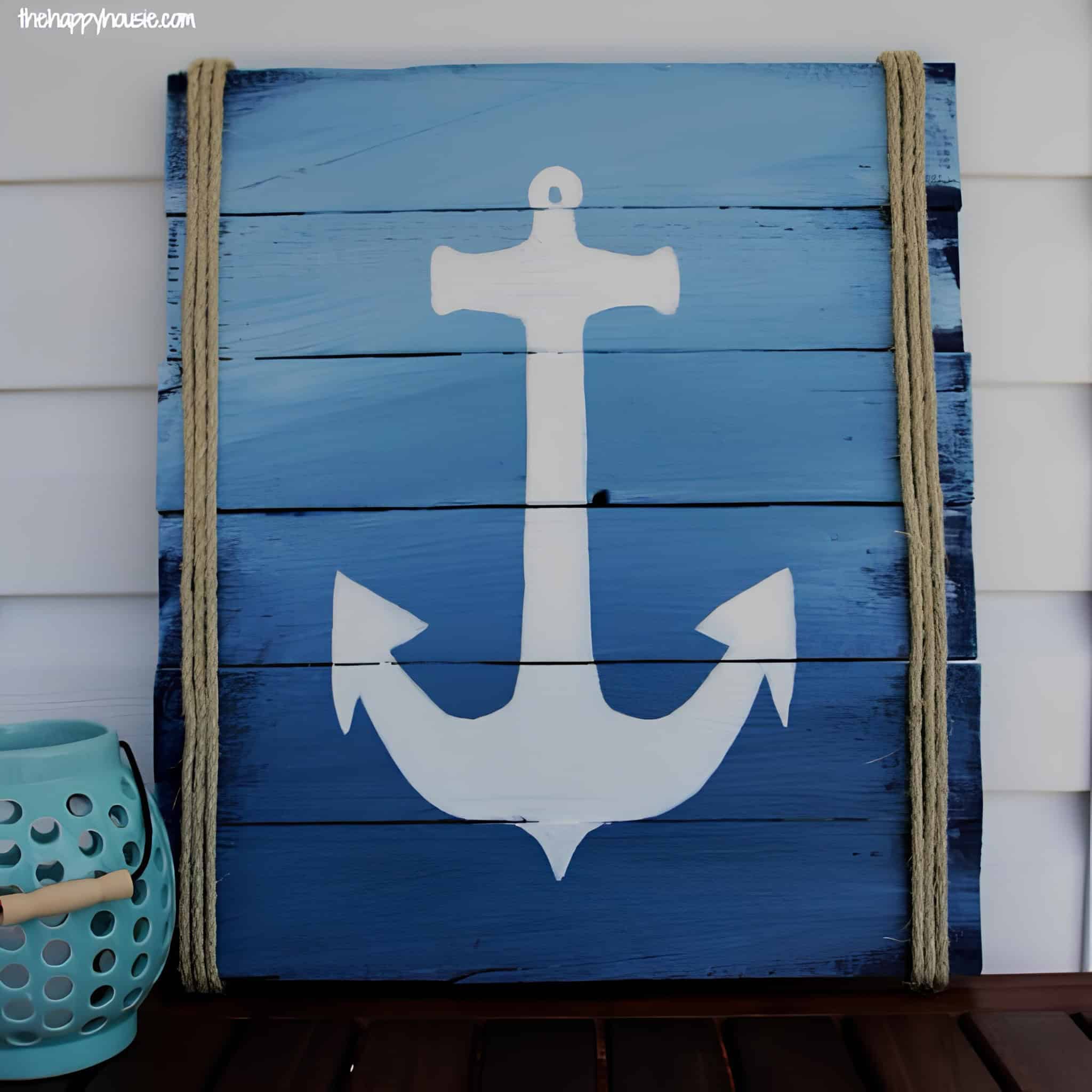 Blue ombre wooden pallet with a white anchor and rope accents on each side.