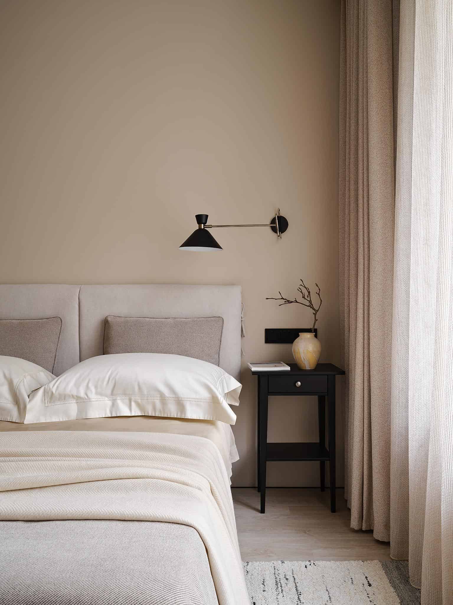 Neutral Bedroom with Black Nightstands Neutral bedroom interior featuring twin black nightstands and wall sconces for ambient lighting.