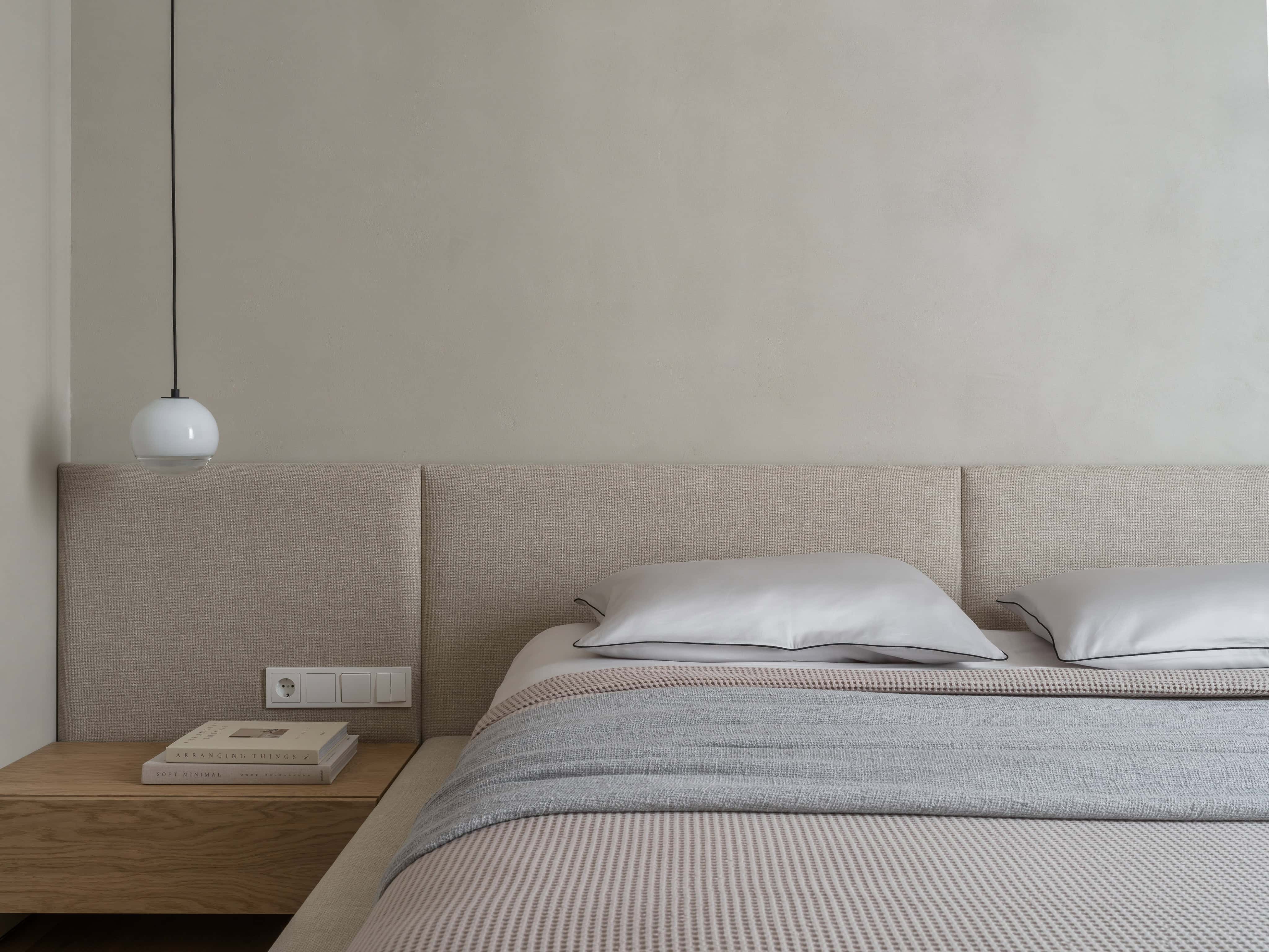 Side Bed View with Ceramic Vase Textured ceramic vase and minimalist decor complement the low-profile bed design.