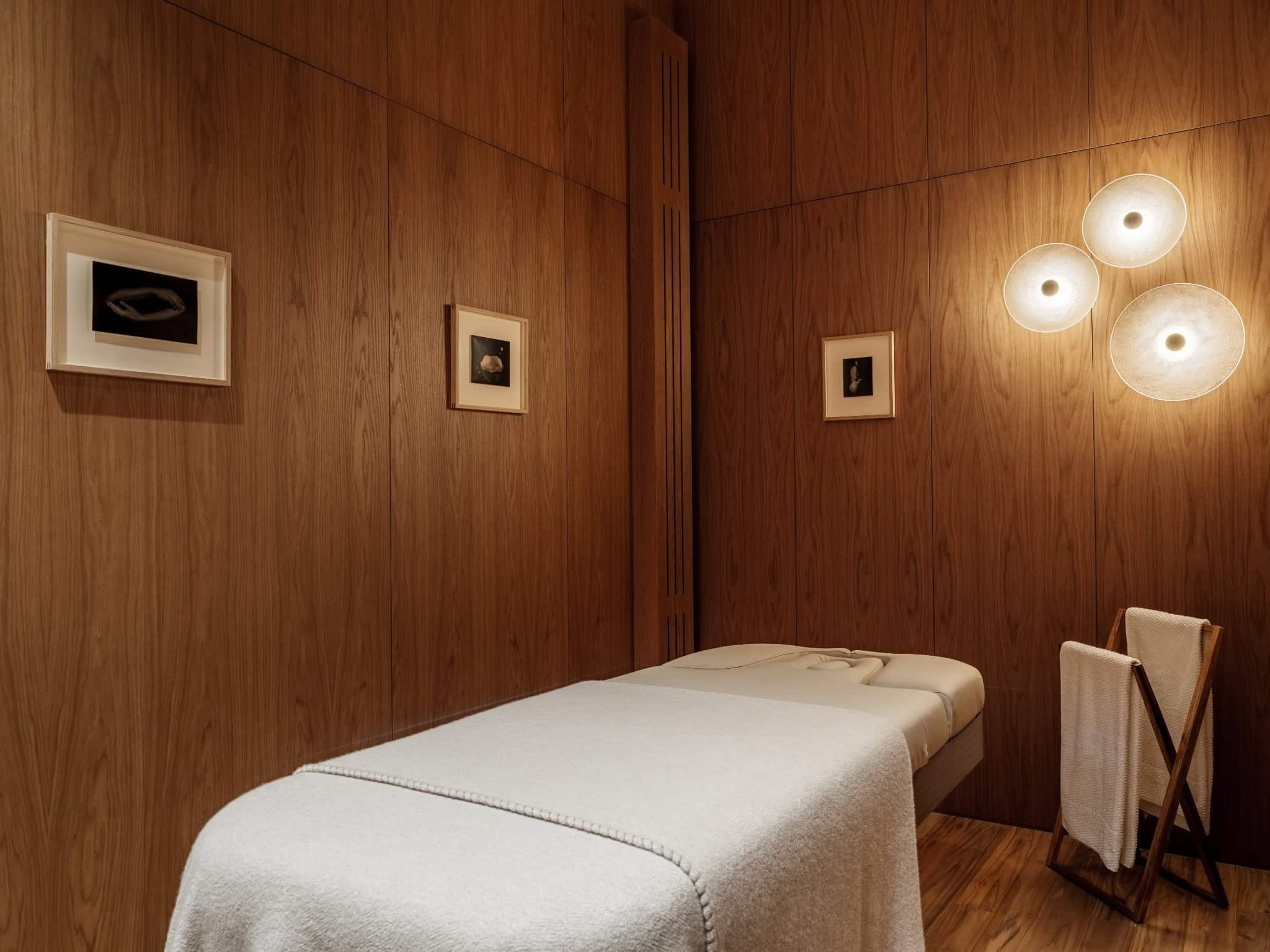 Spa Massage Room with Wood Paneling Tranquil spa massage room with soft lighting and minimalist wood walls.