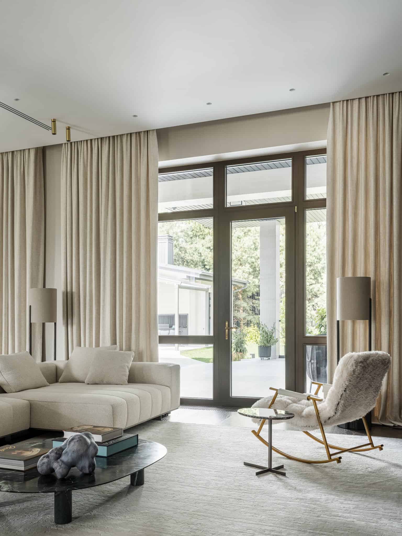 Sunlit Living Space with Large Windows Spacious interior with large glass doors leading to the garden.