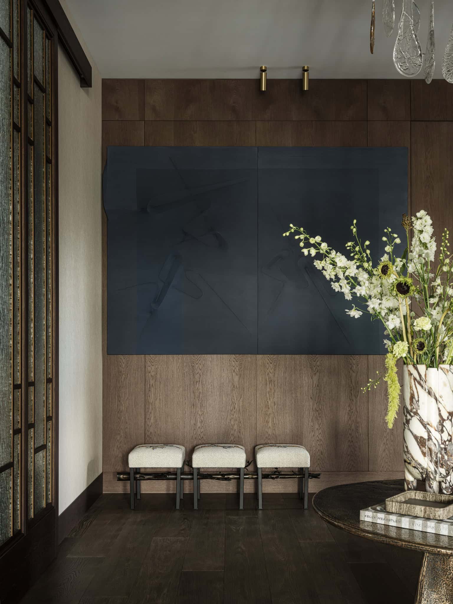 Three Upholstered Stools Beneath Modern Art Set of three upholstered stools beneath a large dark blue abstract painting.