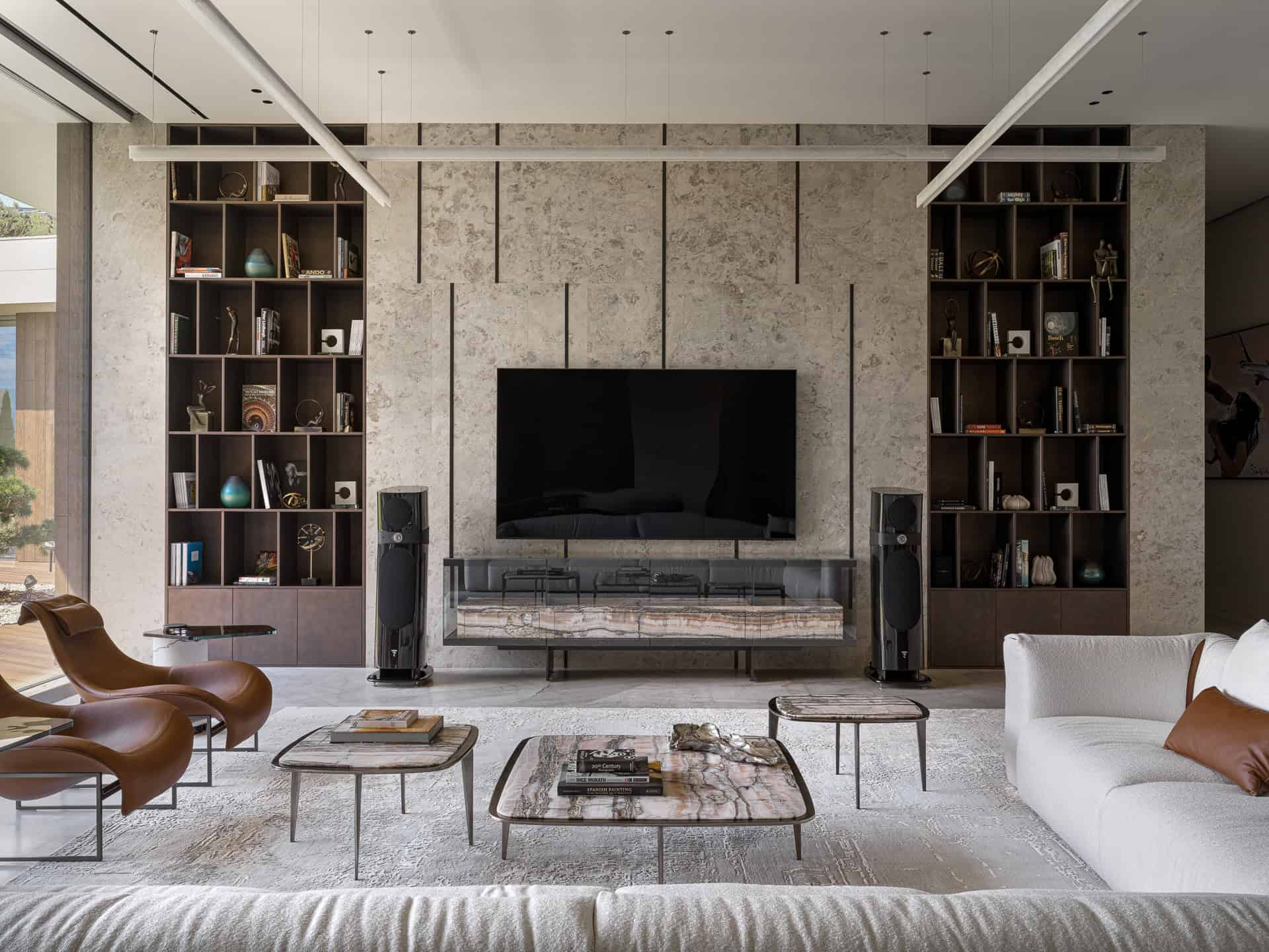 TV Wall with Built-In Shelves Contemporary TV wall with integrated dark shelving and textured stone backdrop.