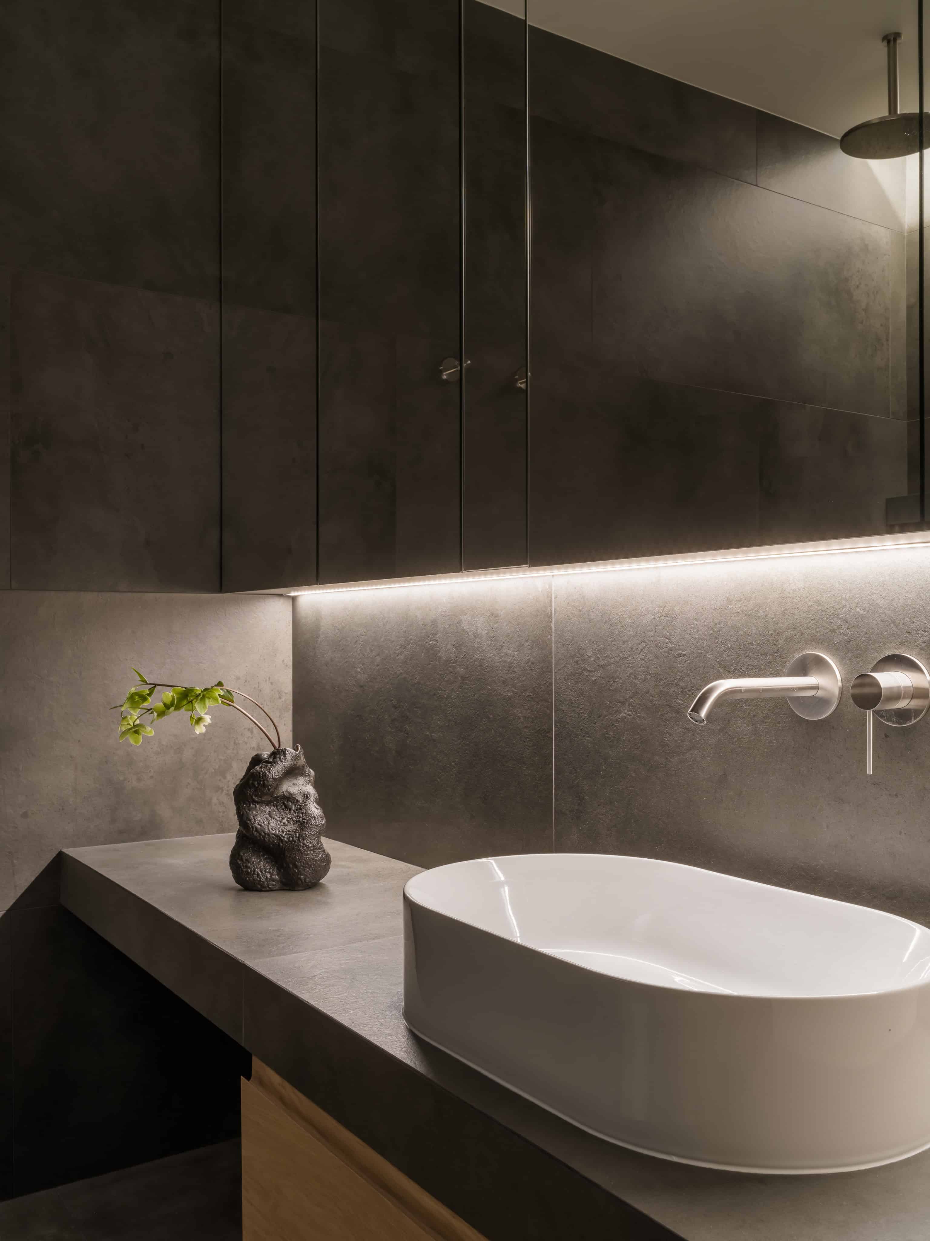 Vessel Sink Dark Stone Vanity White vessel sink on a dark stone vanity top with soft lighting.