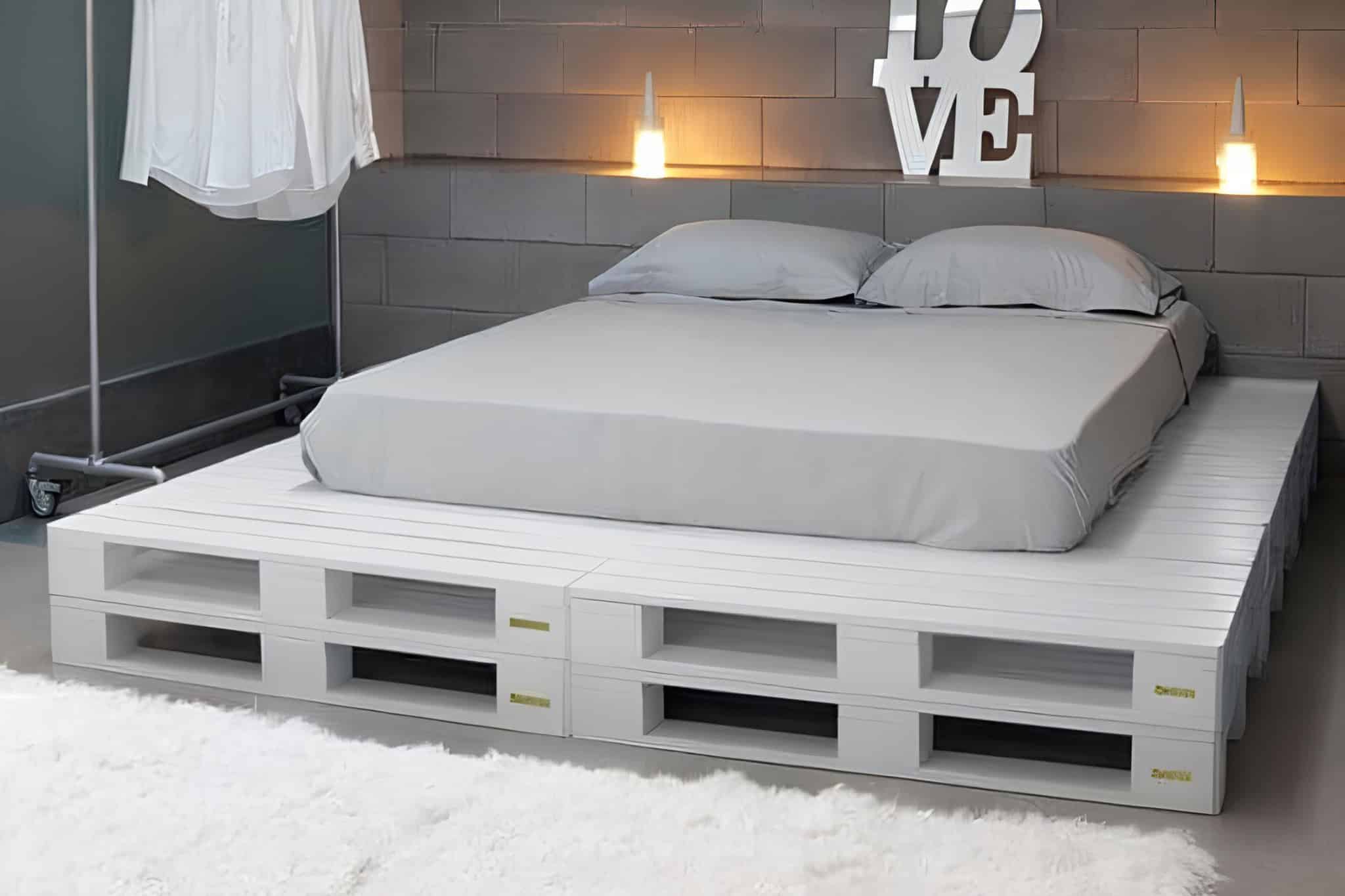 Minimalist white-painted pallet bed base for a modern industrial bedroom.