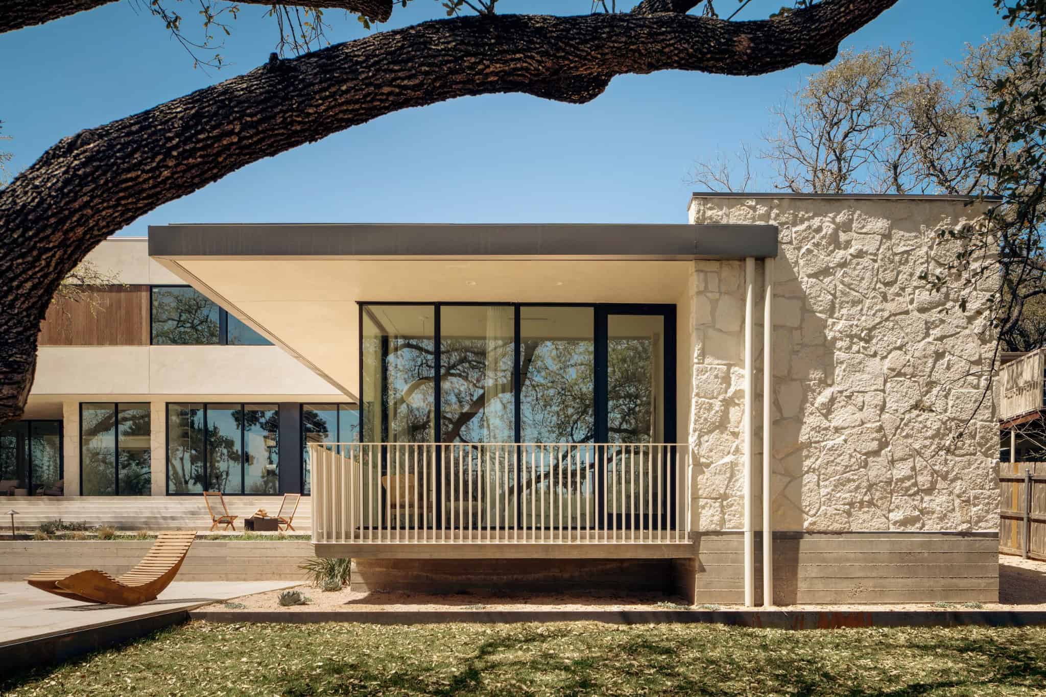 Casa Solis Stone Wall and Glass Façade Side view of Casa Solis showing textured stone wall and large glass panels.