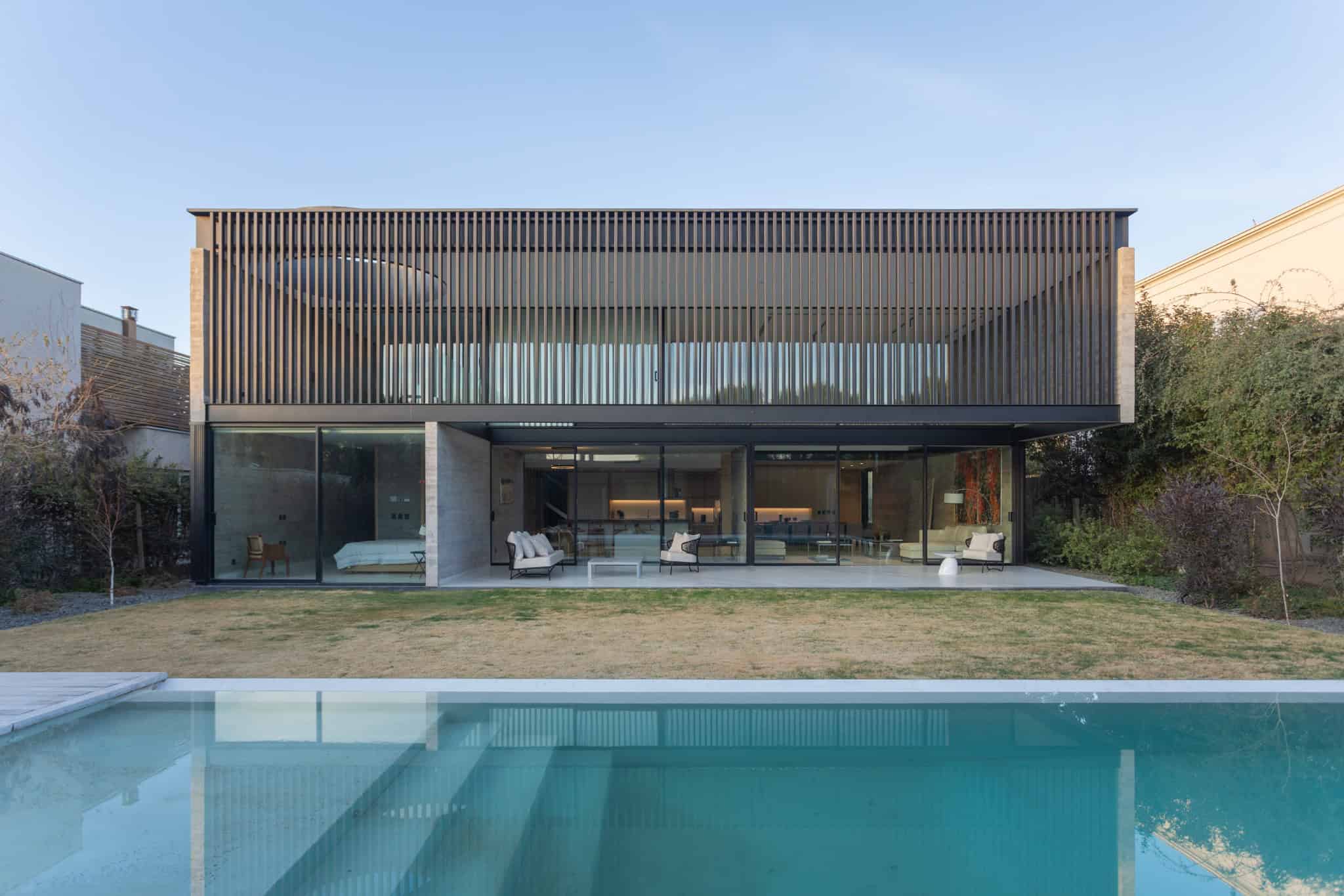 Contemporary modern house with a sleek design, large glass windows, and a private swimming pool, showcasing innovative architecture and luxury outdoor living spaces.