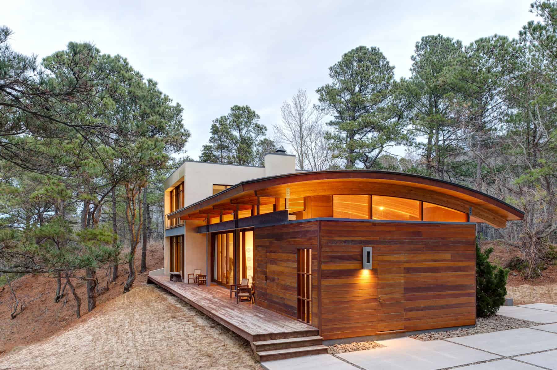 Modern Arched Roof House with Wooden Exterior in Forest Modern house with arched roof, timber cladding, and forest surroundings