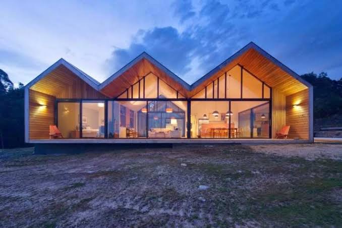 Modern M-Shaped Roof House with Glass Facade Modern house with M-shaped roof, floor-to-ceiling glass facade, and wood cladding