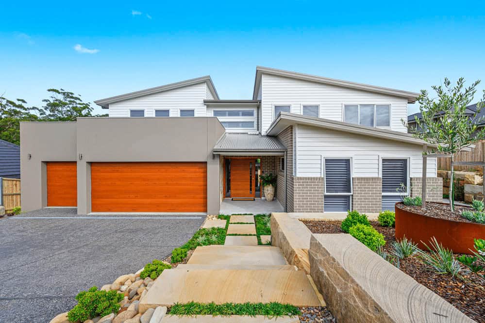 Modern Skillion Roof House with Wooden Garage Doors Modern home with skillion roof, wooden garage doors, and minimalist landscaping