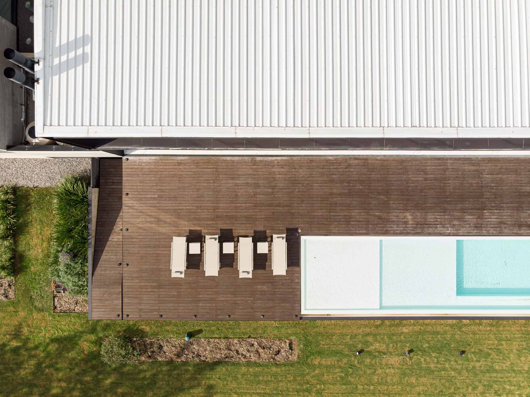 Pacheco House by A4estudio 05 Aerial view of terrace and sun loungers beside the pool.