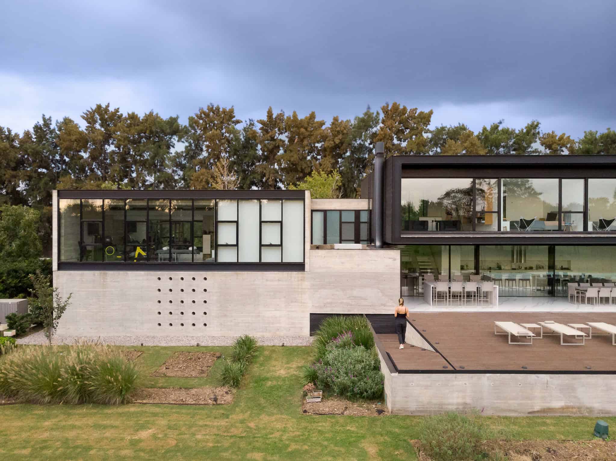 Pacheco House by A4estudio 07 Close-up view of annexed volume of Pacheco House with woman standing.